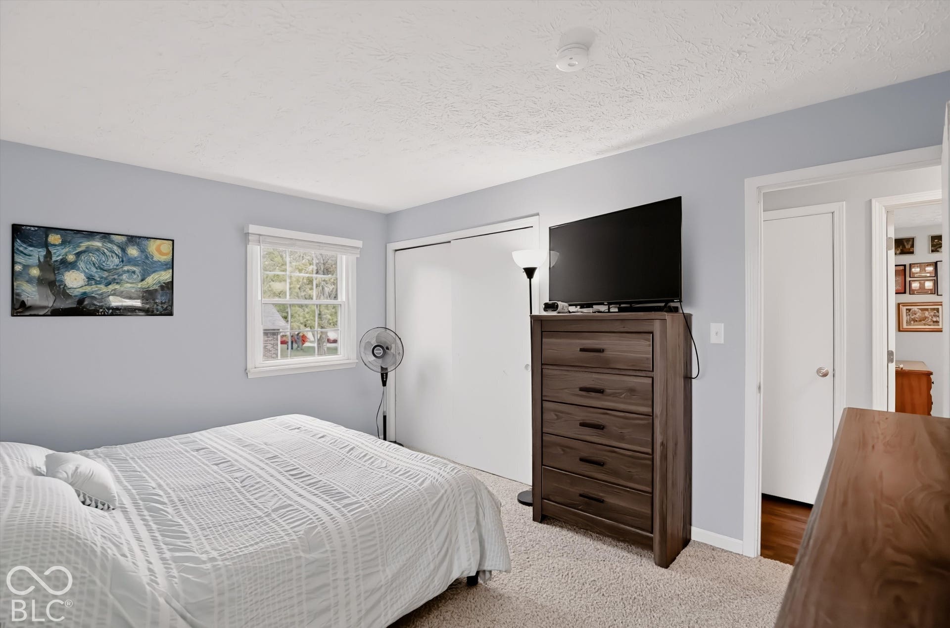 Neutral wall color, dual-panel sliding closet doors, and a single-pane window