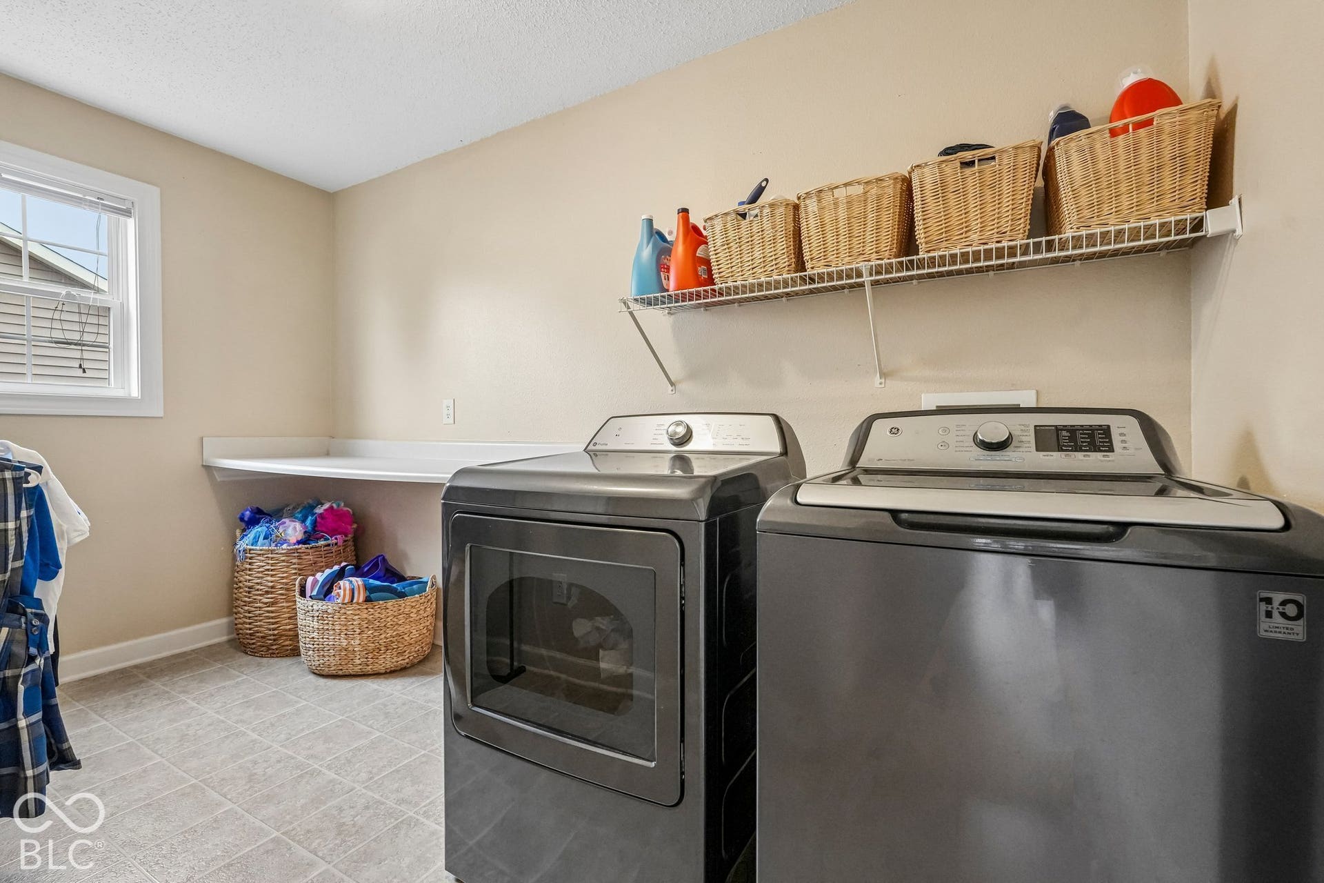 Conveniently located upstairs laundry room includes washer and dryer and folding table