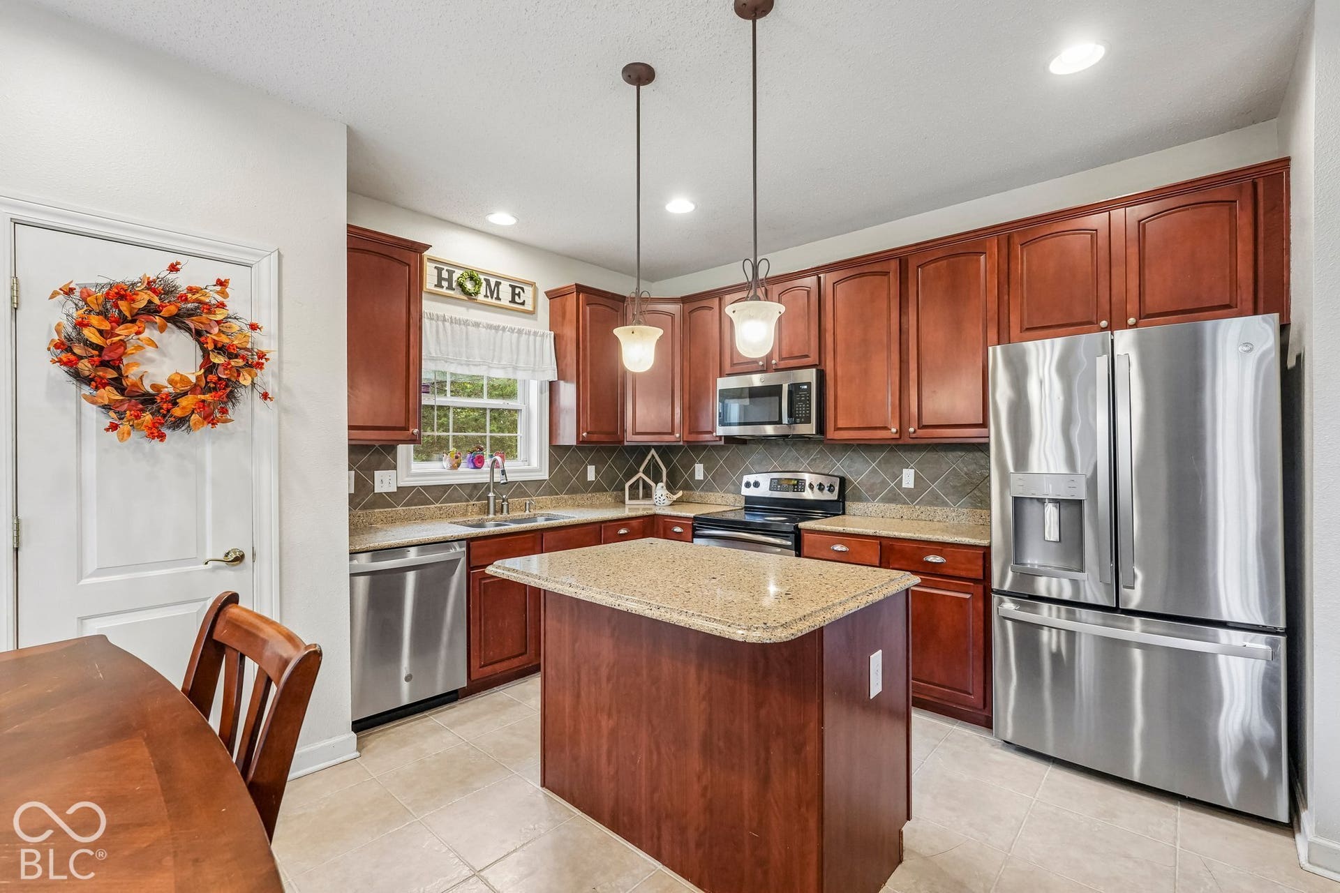 Kitchen offers Stainless Steel appliances, center island, pendant lighting, granite counters and pantry