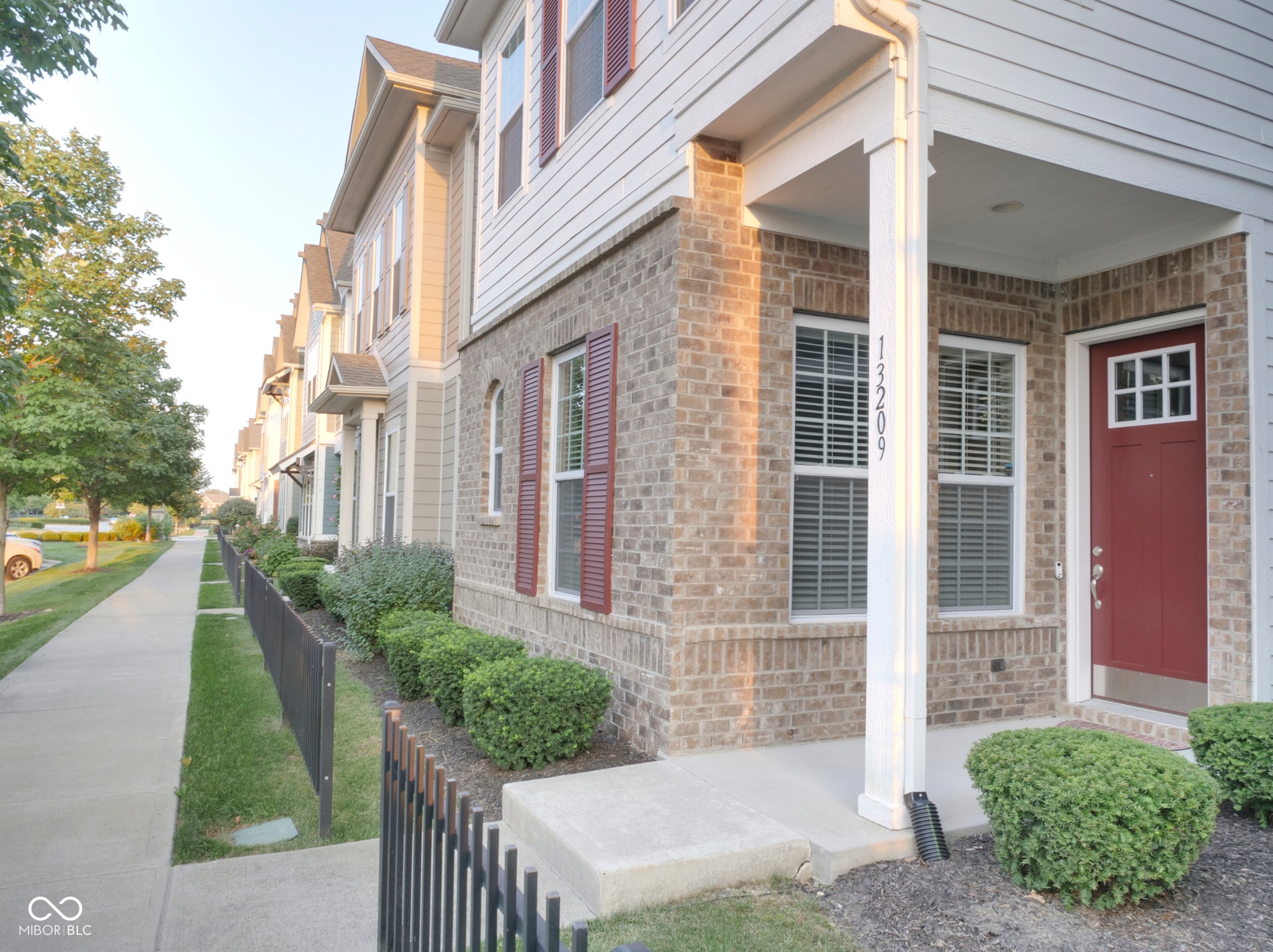 Brick and siding exterior with red shutters