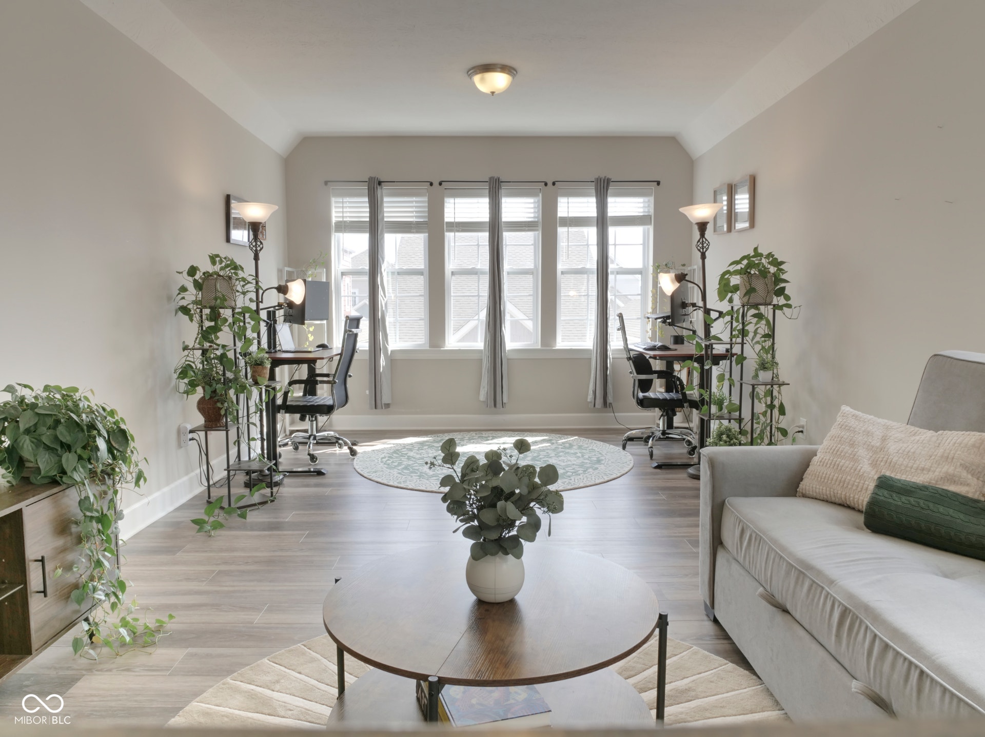 Recessed ceiling with an attached light fixture, a bay window with multiple panes, wood-finish flooring, and light-toned wall paint