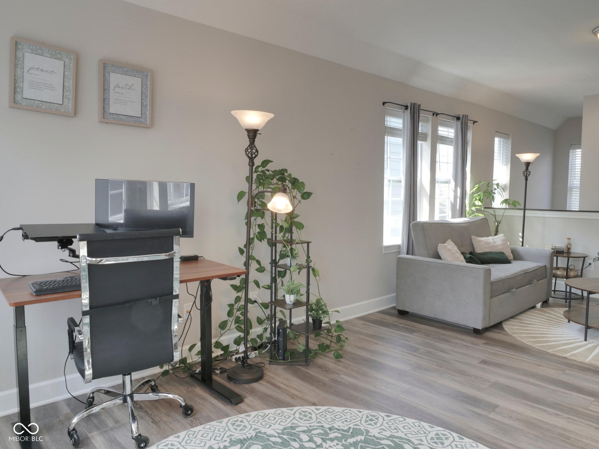 Wood-finish flooring throughout, multiple windows, and a partial wall with a railing
