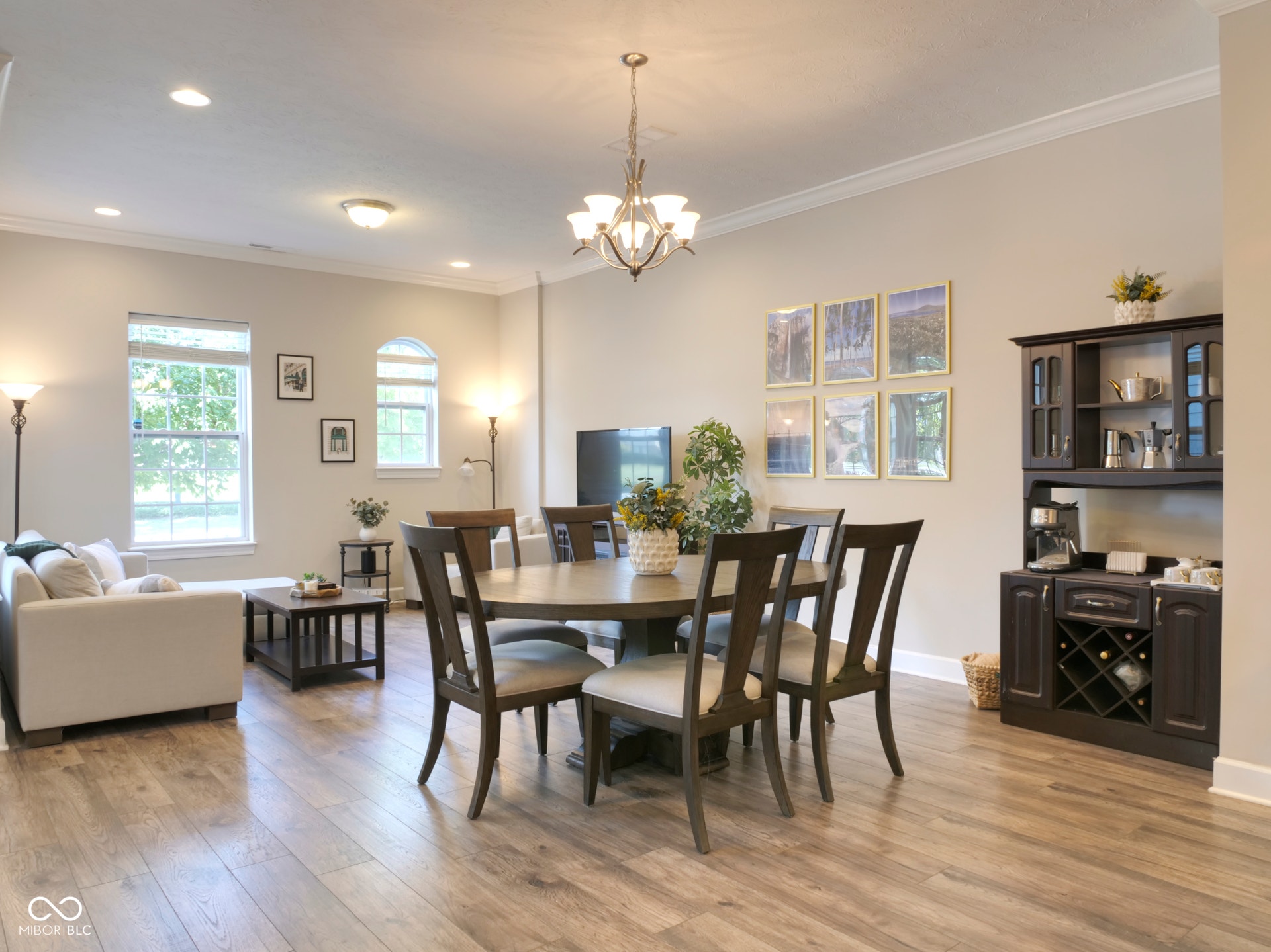 Hardwood-finish flooring throughout, crown molding, recessed lighting, and a built-in beverage bar with wine storage