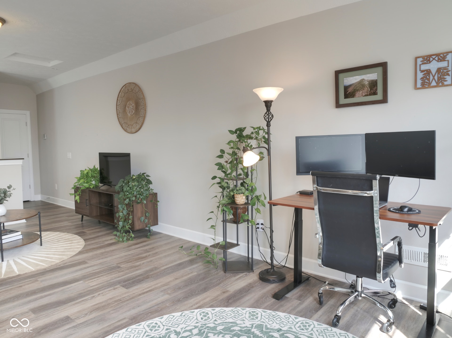 Wood-finish flooring, light neutral wall paint, white trim, and a built-in media console