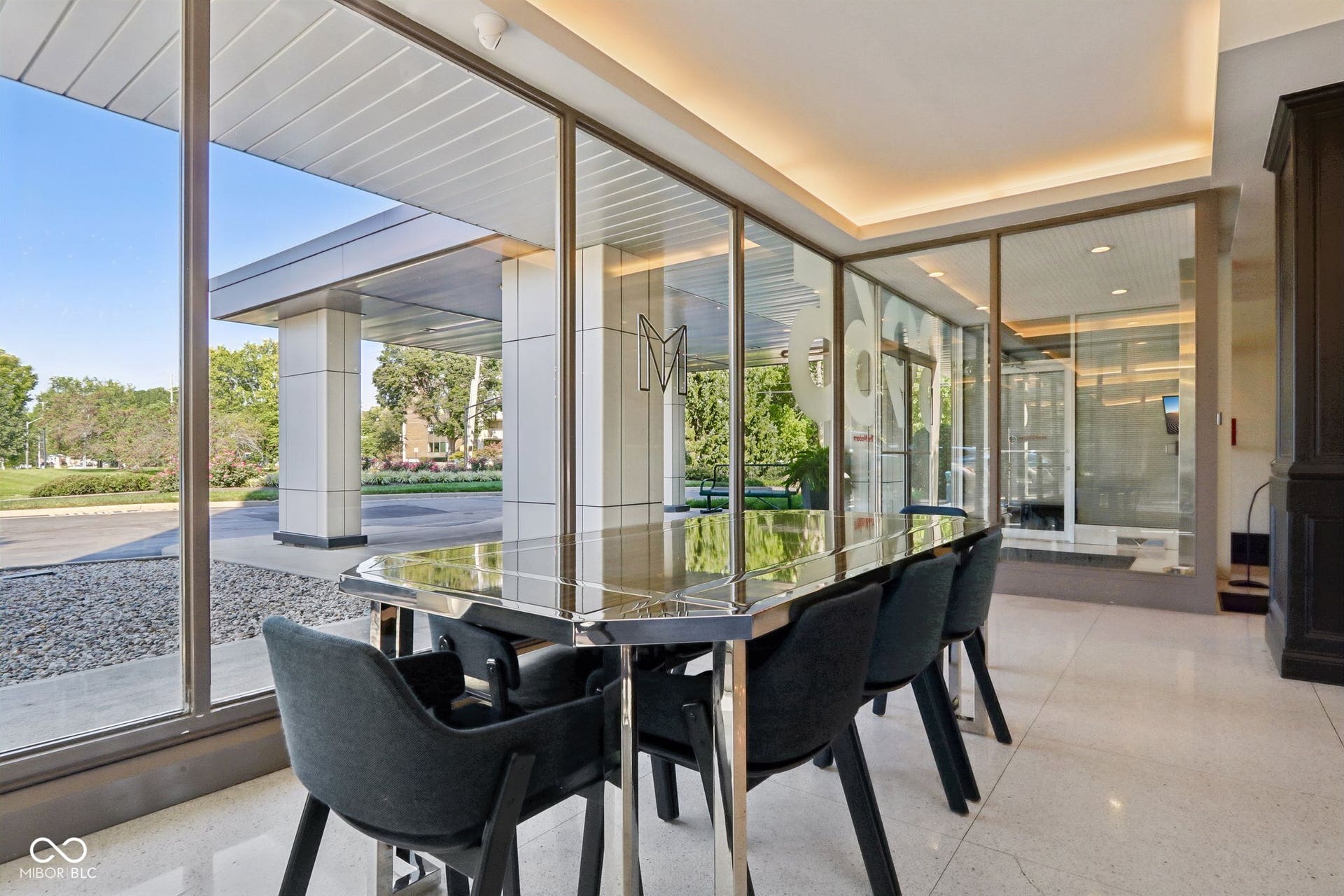 East building: an additional lobby with Floor-to-ceiling windows, polished flooring, recessed ceiling lighting, and a prominent exterior porte-cochere