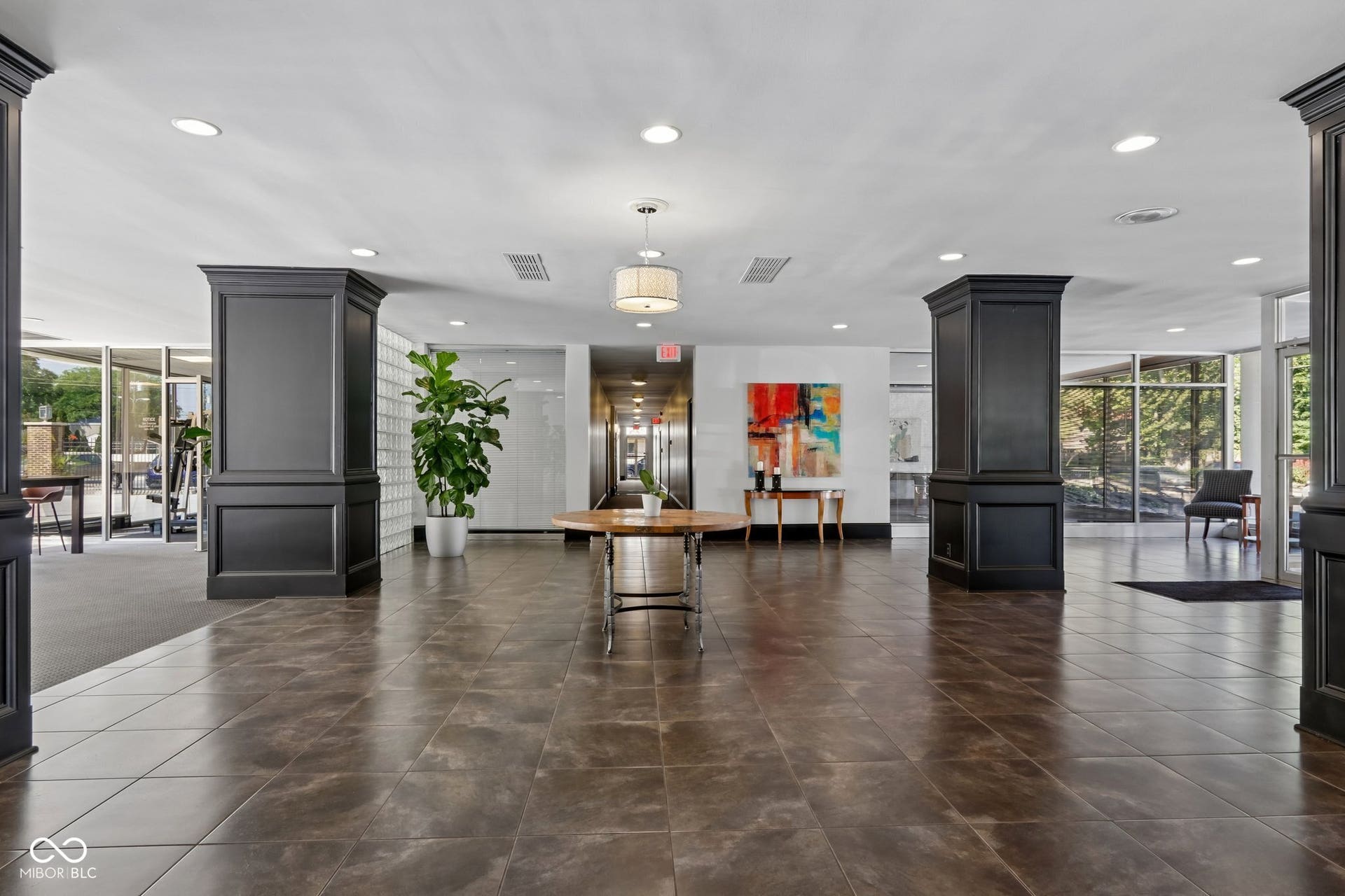 East building: Spacious lobby featuring large format floor tiling, recessed lighting, and decorative columns