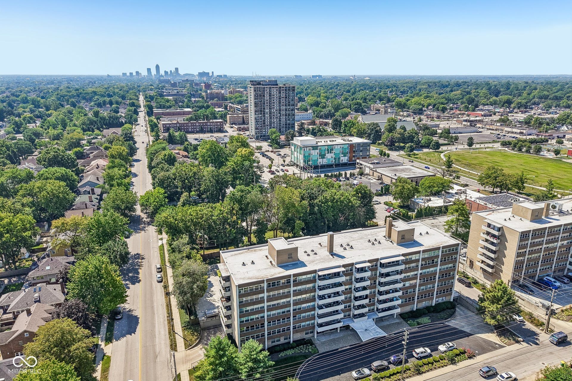 Multi-story building featuring multiple balconies, a structured facade, and an integrated entrance canopy