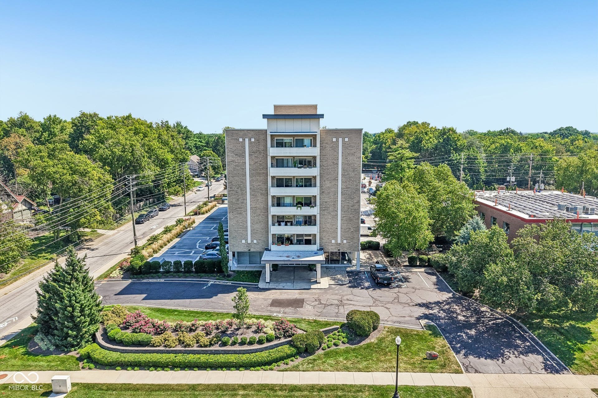 Multi-story building featuring a brick facade with balconies and an integrated covered entrance