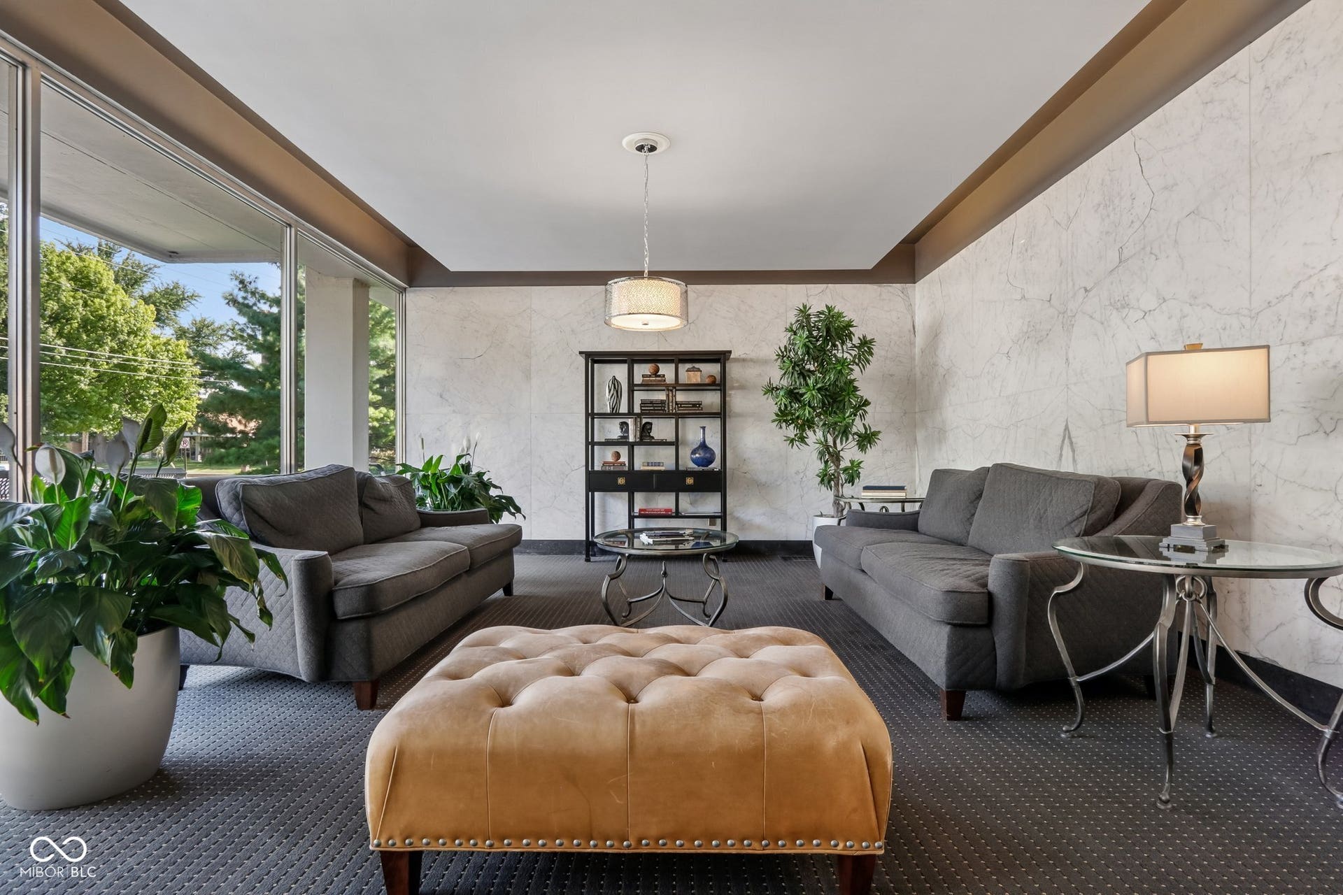 East building: Expansive window wall, textured accent wall, recessed ceiling detail, and ceiling-mounted light fixture