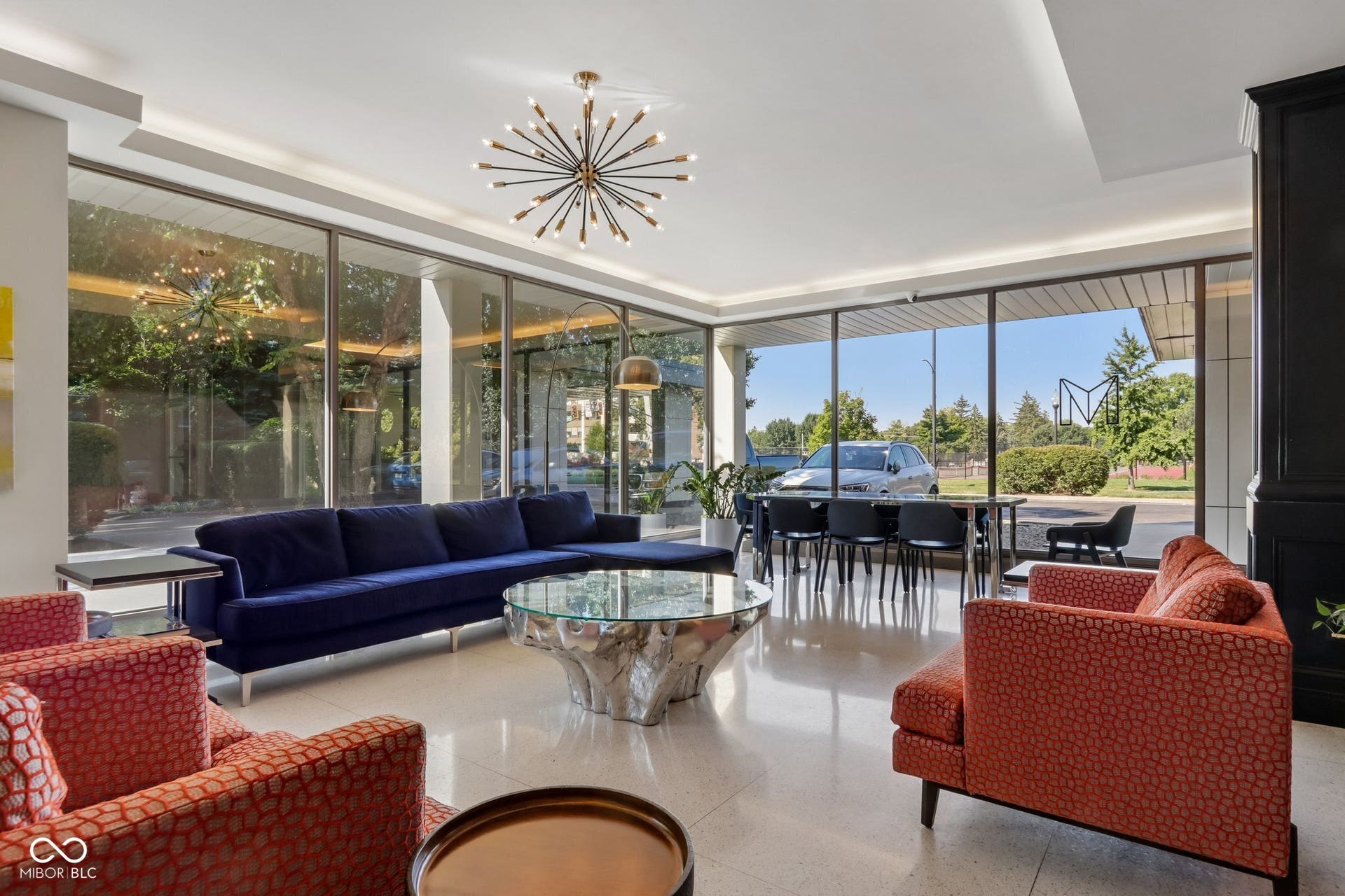 West building: Expansive floor-to-ceiling windows, recessed ceiling lighting, and a modern sputnik chandelier