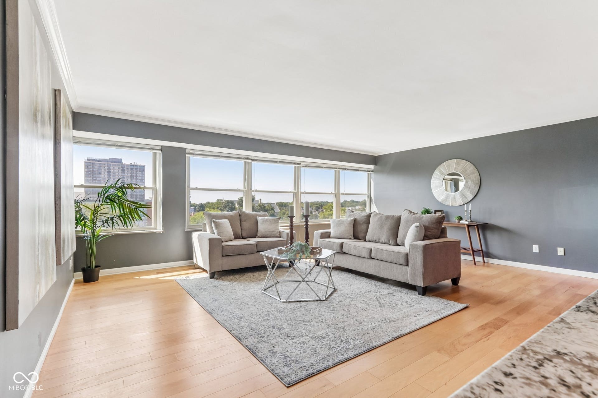Hardwood flooring, crown molding, expansive windows, recessed lighting, and a neutral color palette