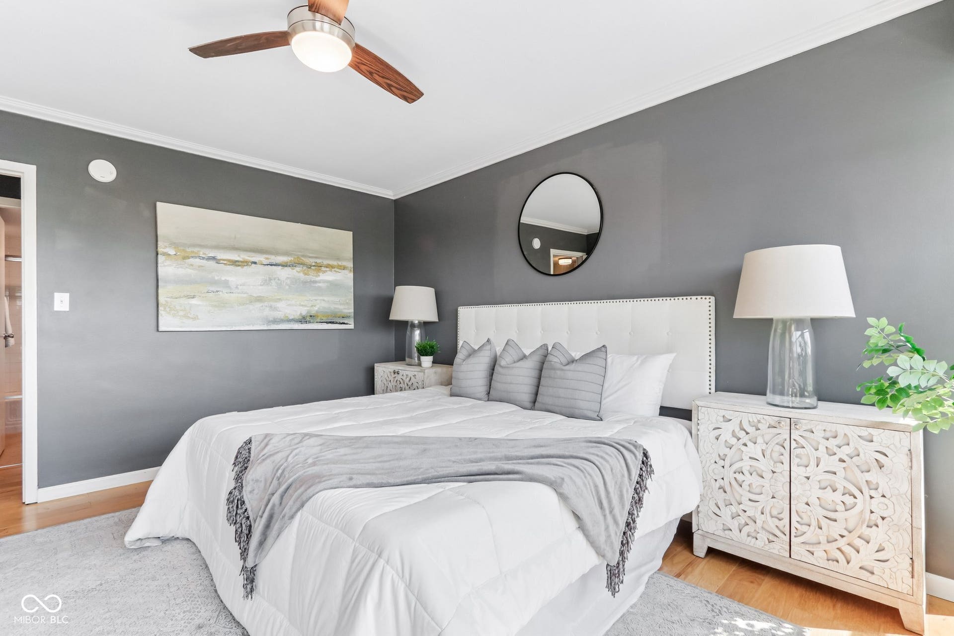 Wood-finish flooring with crown molding and a ceiling fan