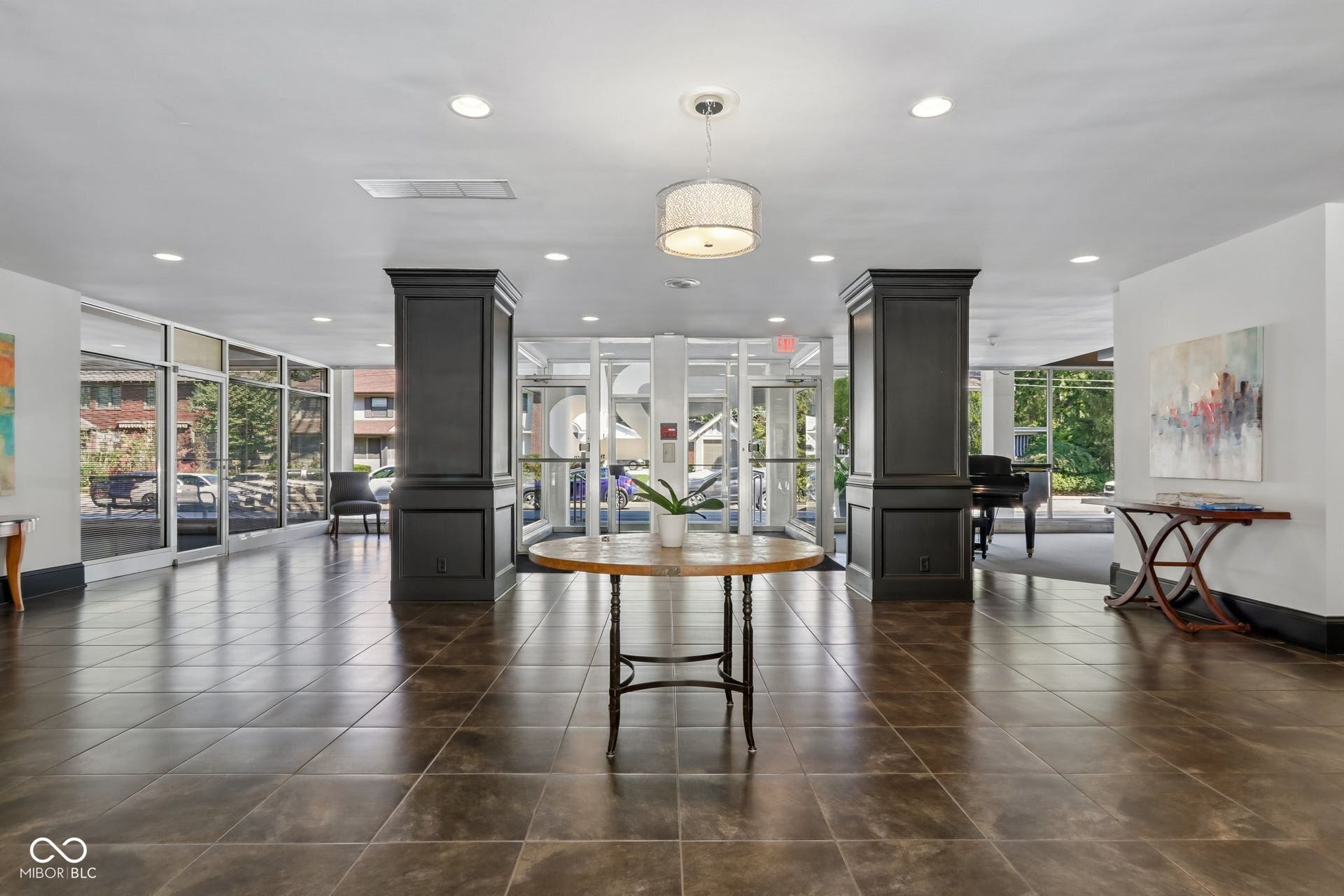 East Building: Spacious lobby featuring large format floor tiles, recessed lighting, and a decorative pendant light fixture