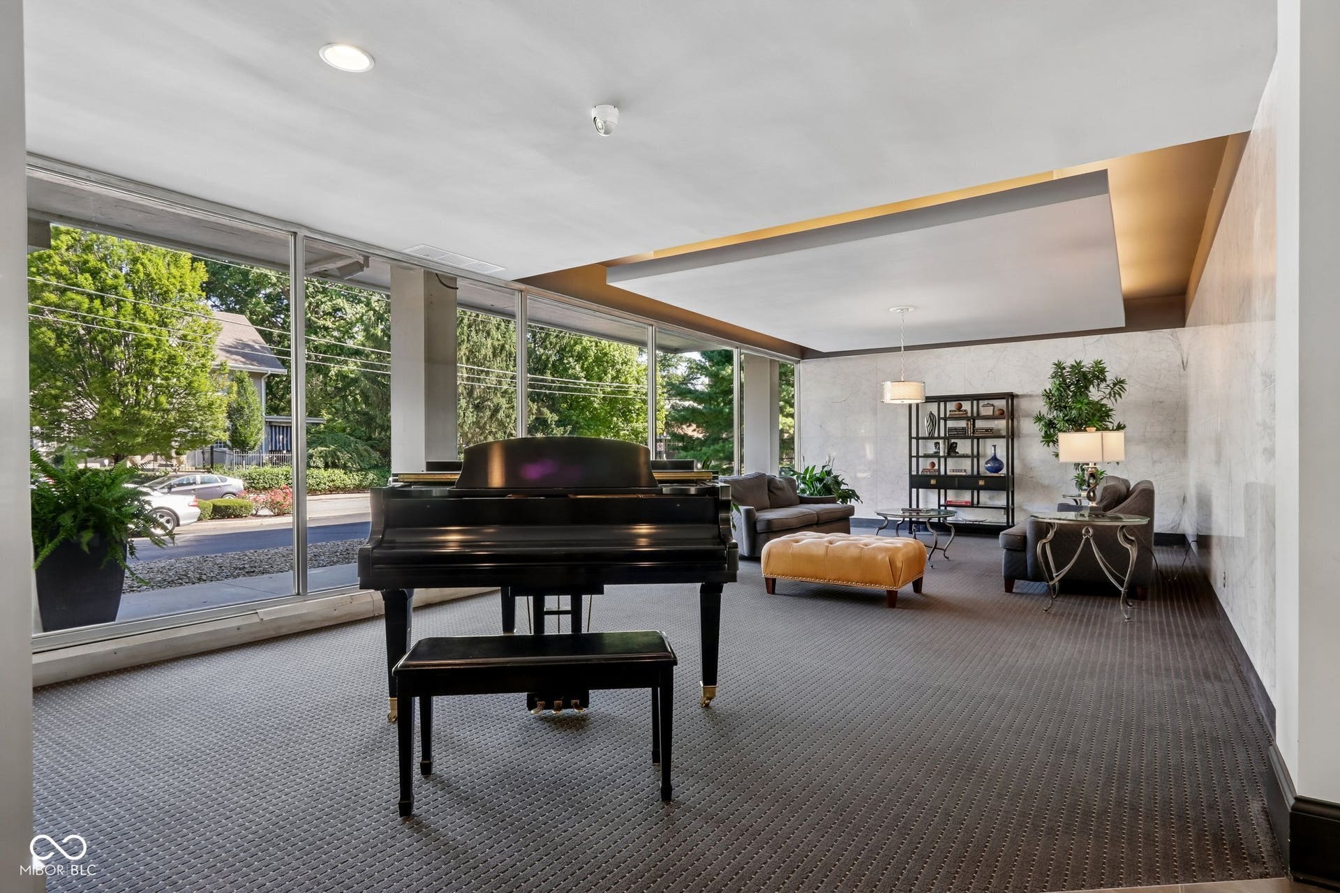 East building: Spacious common area featuring full-height windows, recessed lighting, and a suspended ceiling with accent lighting