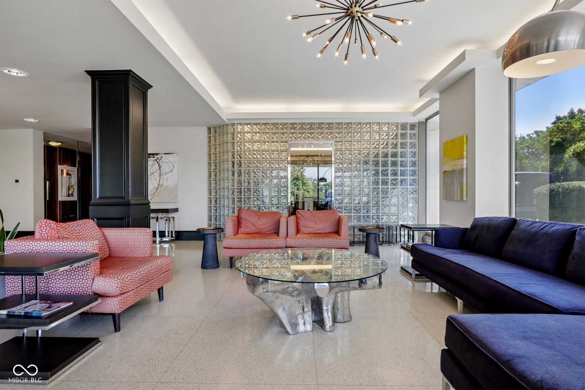 West building: Spacious common area featuring large format tile flooring, a glass block wall, and recessed ceiling lighting