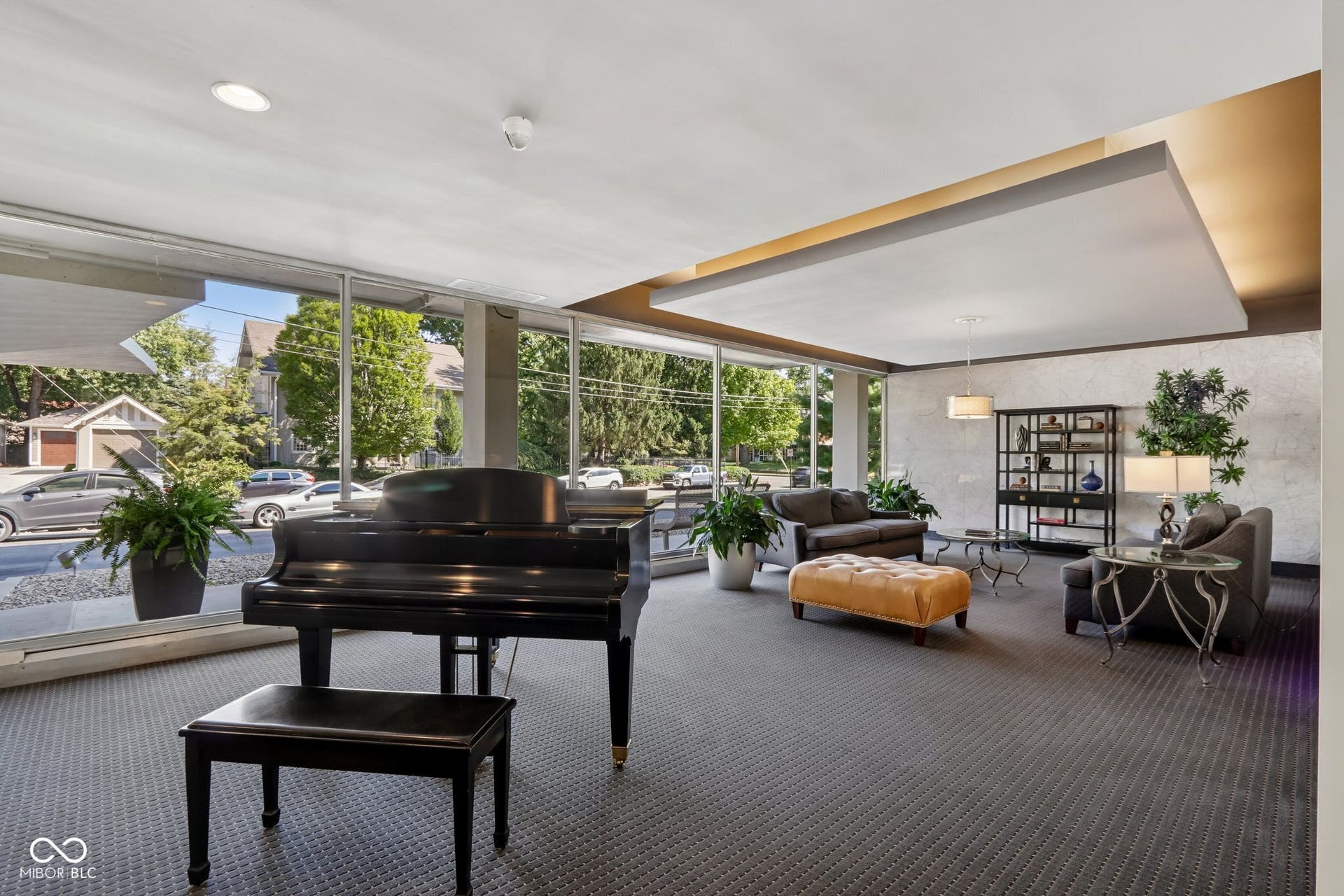 East building: Expansive windows, coffered ceiling with recessed lighting, patterned carpet flooring, and a decorative pendant light fixture