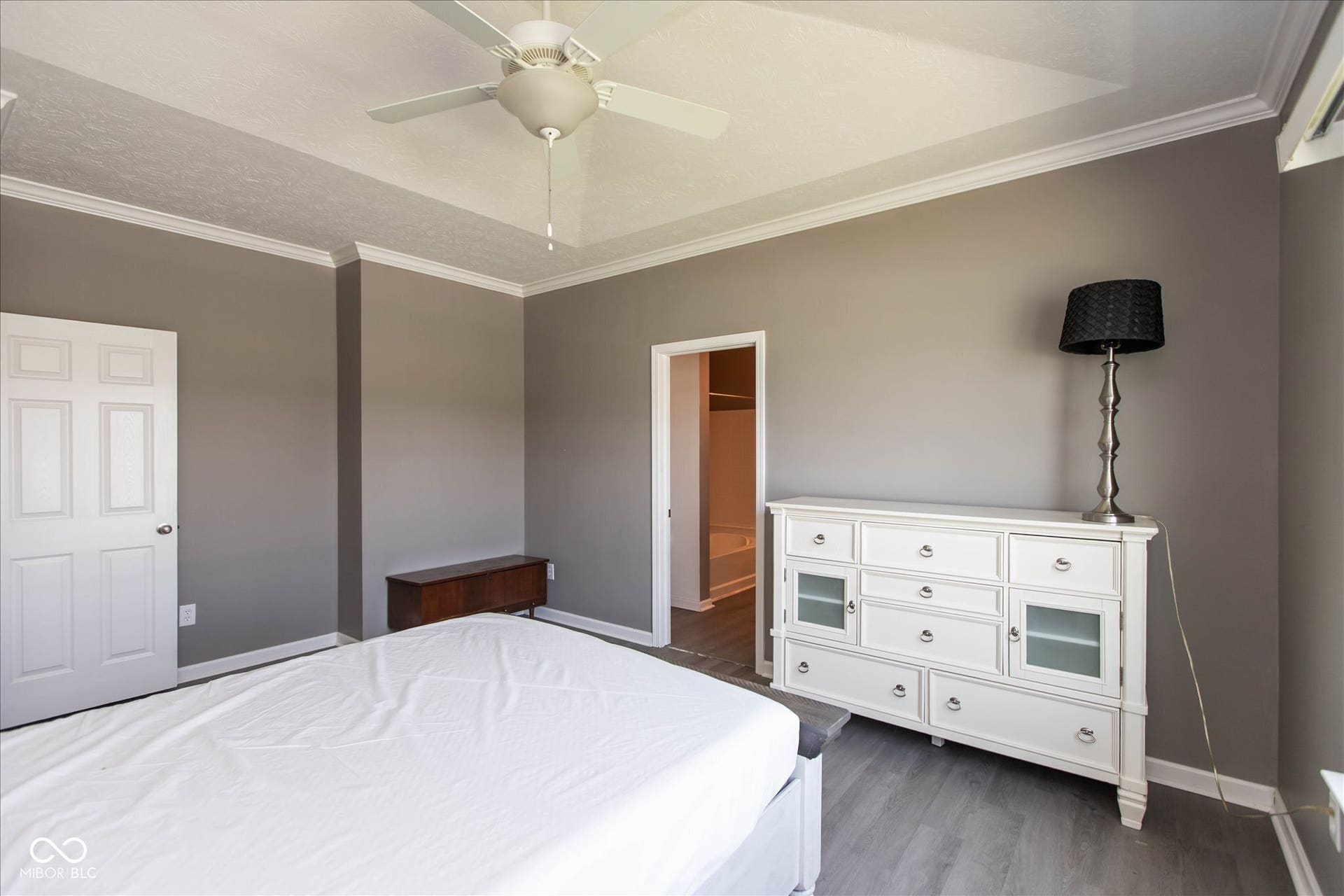 Spacious interior room with light gray walls and wood-finish flooring