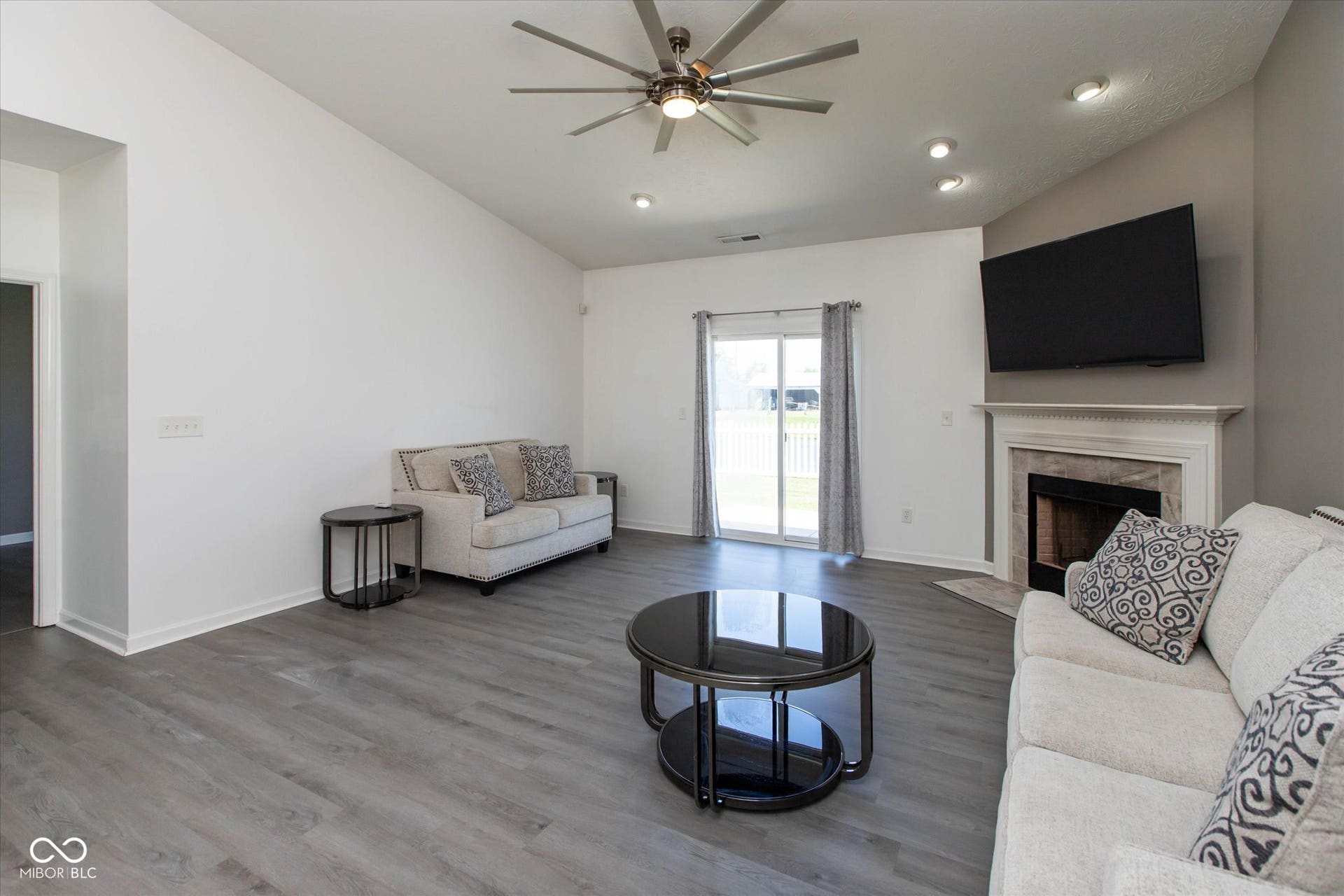 Living room with vaulted ceiling, wood-finish flooring, and recessed lighting