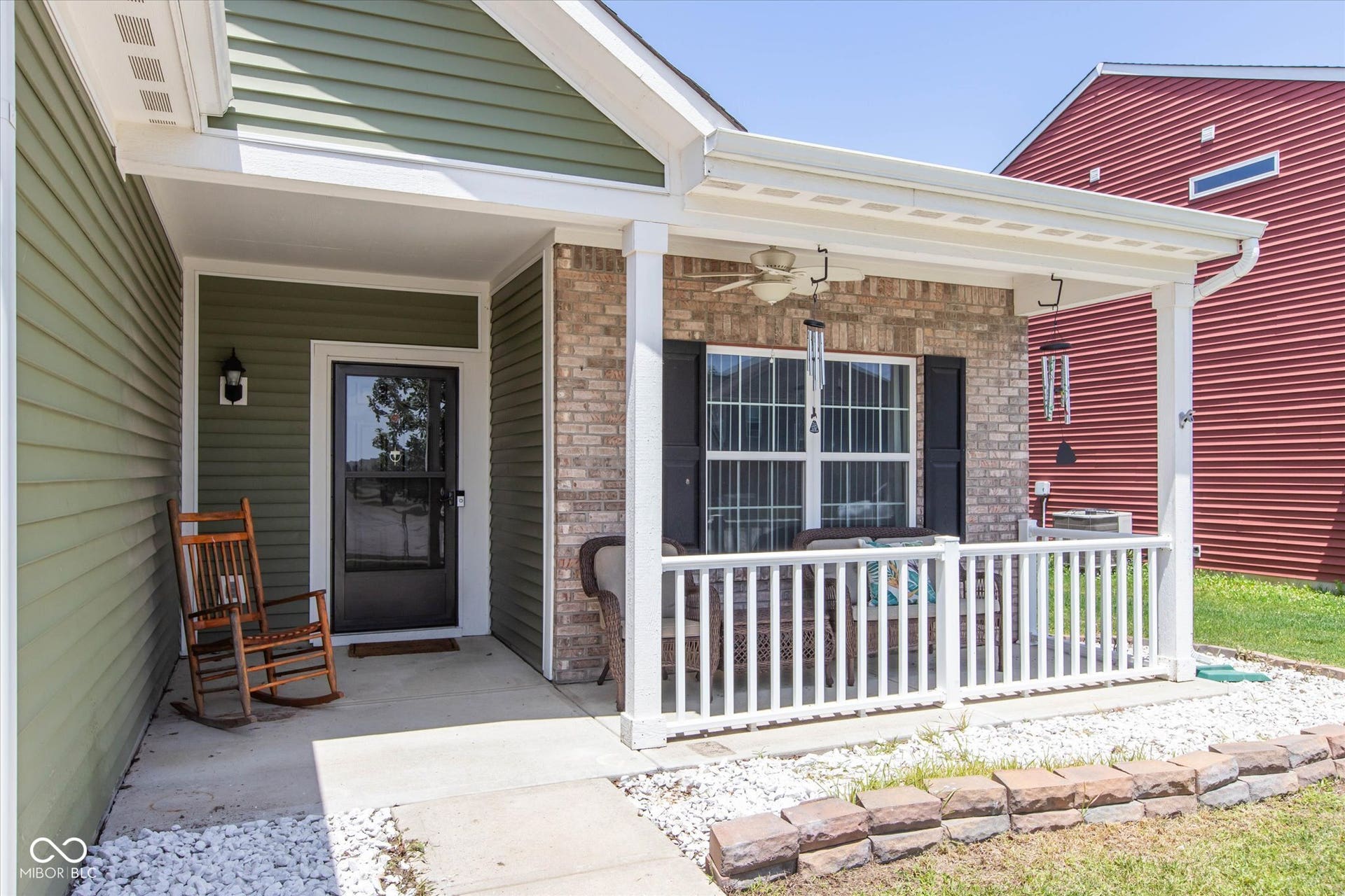 Covered porch featuring brick and siding accents