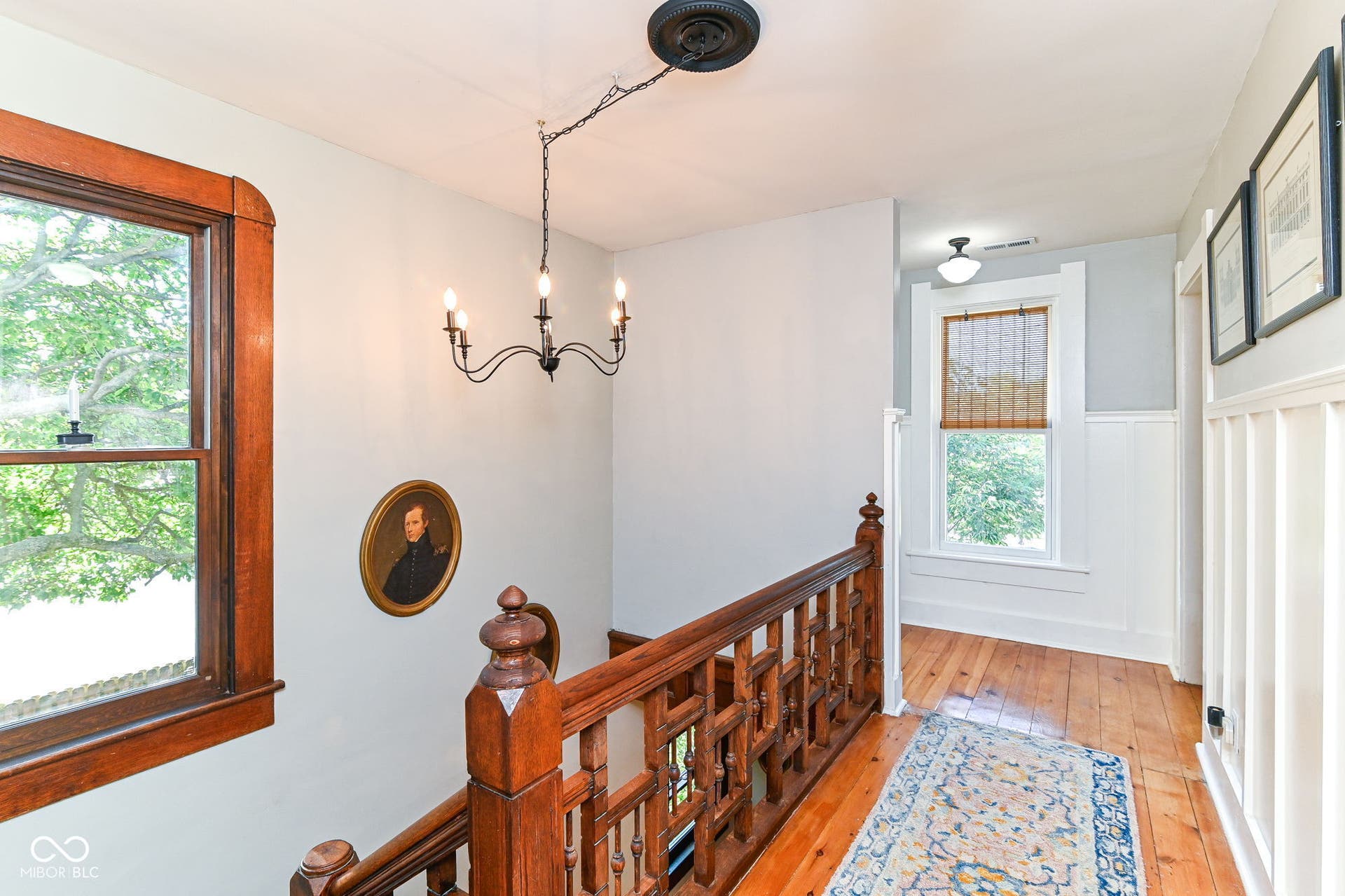 Upstairs landing continues the home's craftsmanship with original wood railings, pine floors and abundant natural light.