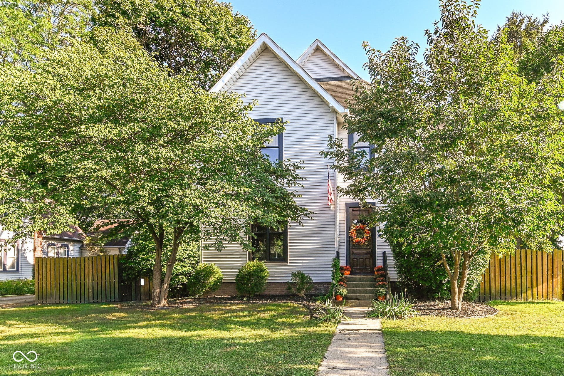 Historic Plainfield charm begins at the curb - 411 E Main Street offers mature trees, a fenced yard and timeless architecture near downtown Plainfield.