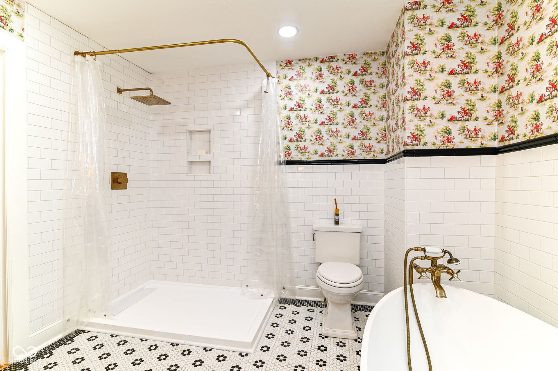 Spa-inspired upstairs bath features a walk-in tiled shower, solid-stone soaking tub and timeless black-and-white flooring.