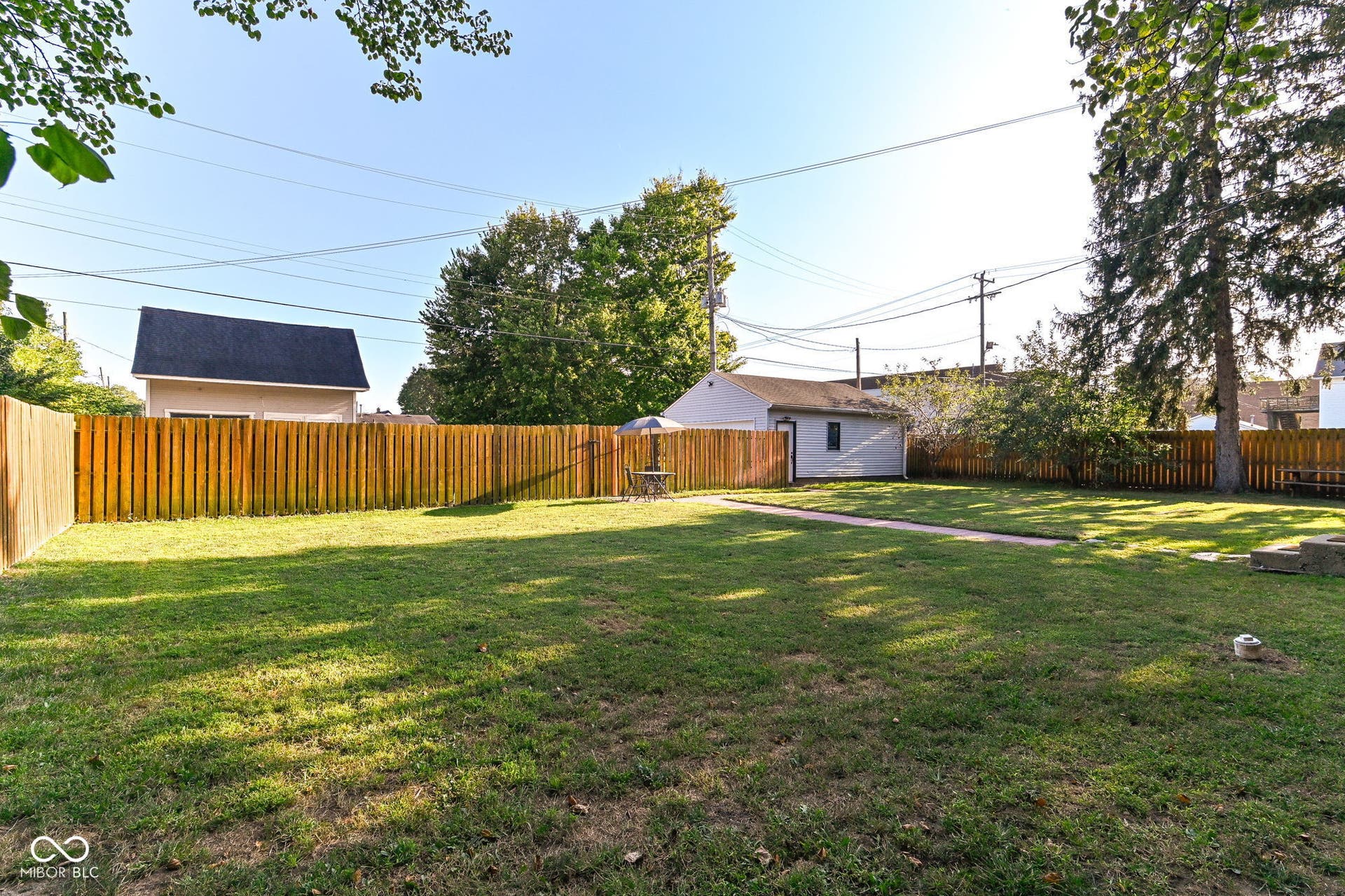 Large fenced lawn creates a private outdoor retreat with mature shade and space for gardening, pets or outdoor gatherings.