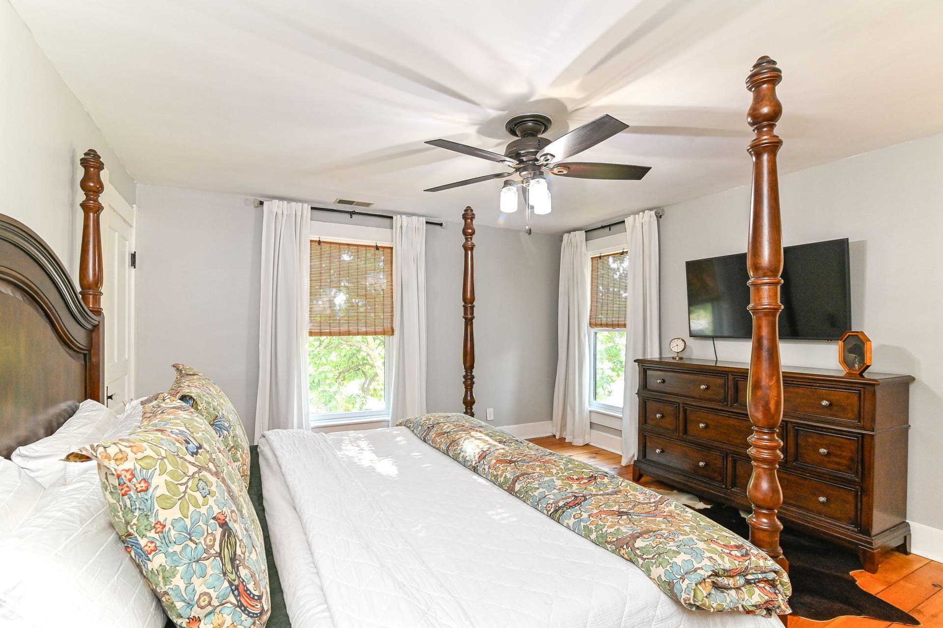 A second angle shows the generous bedroom scale, original pine floors and natural light from multiple windows.