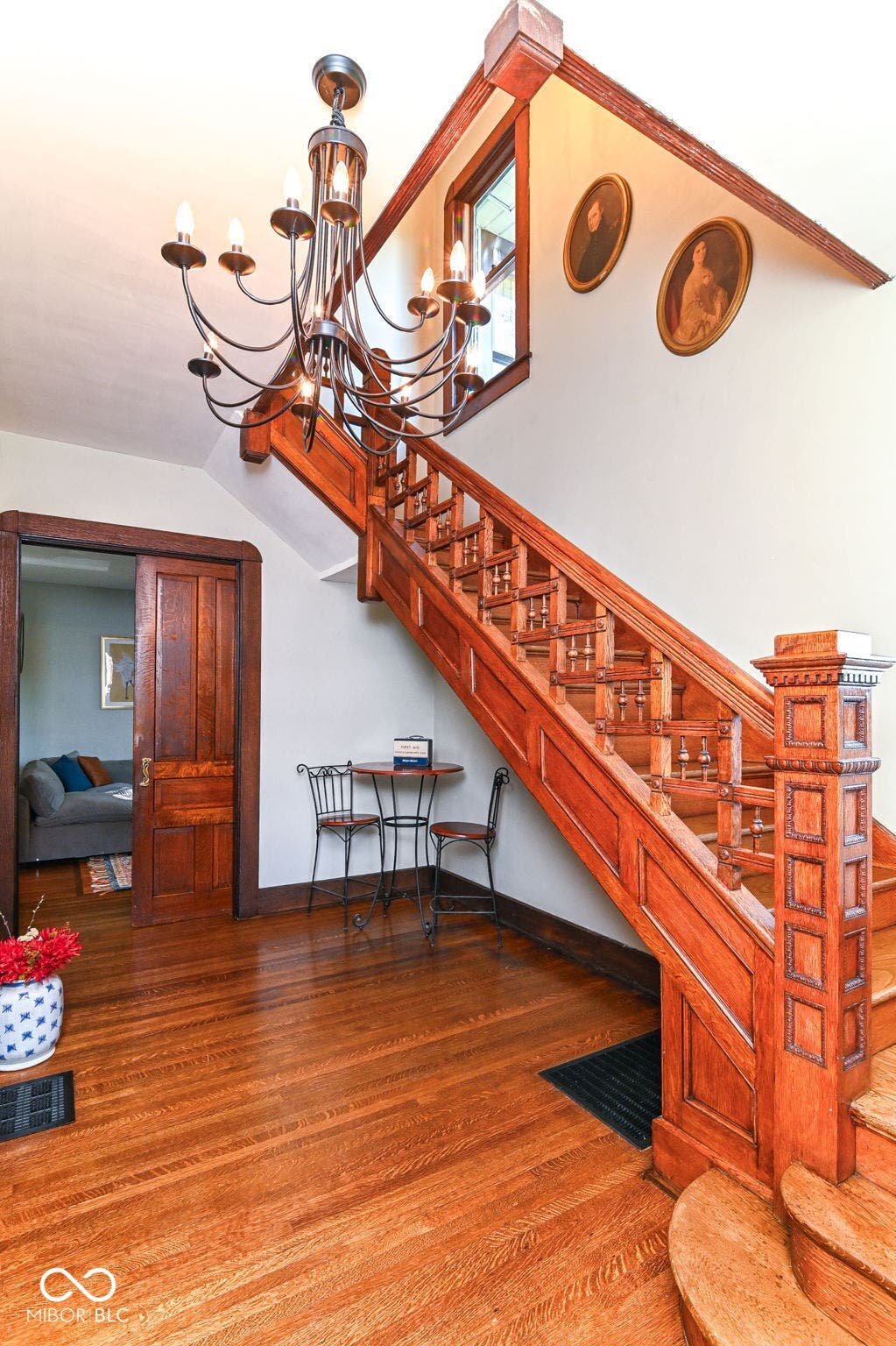 The extraordinary original staircase is a true centerpiece, surrounded by restored wood floors, detailed railings and period craftsmanship.