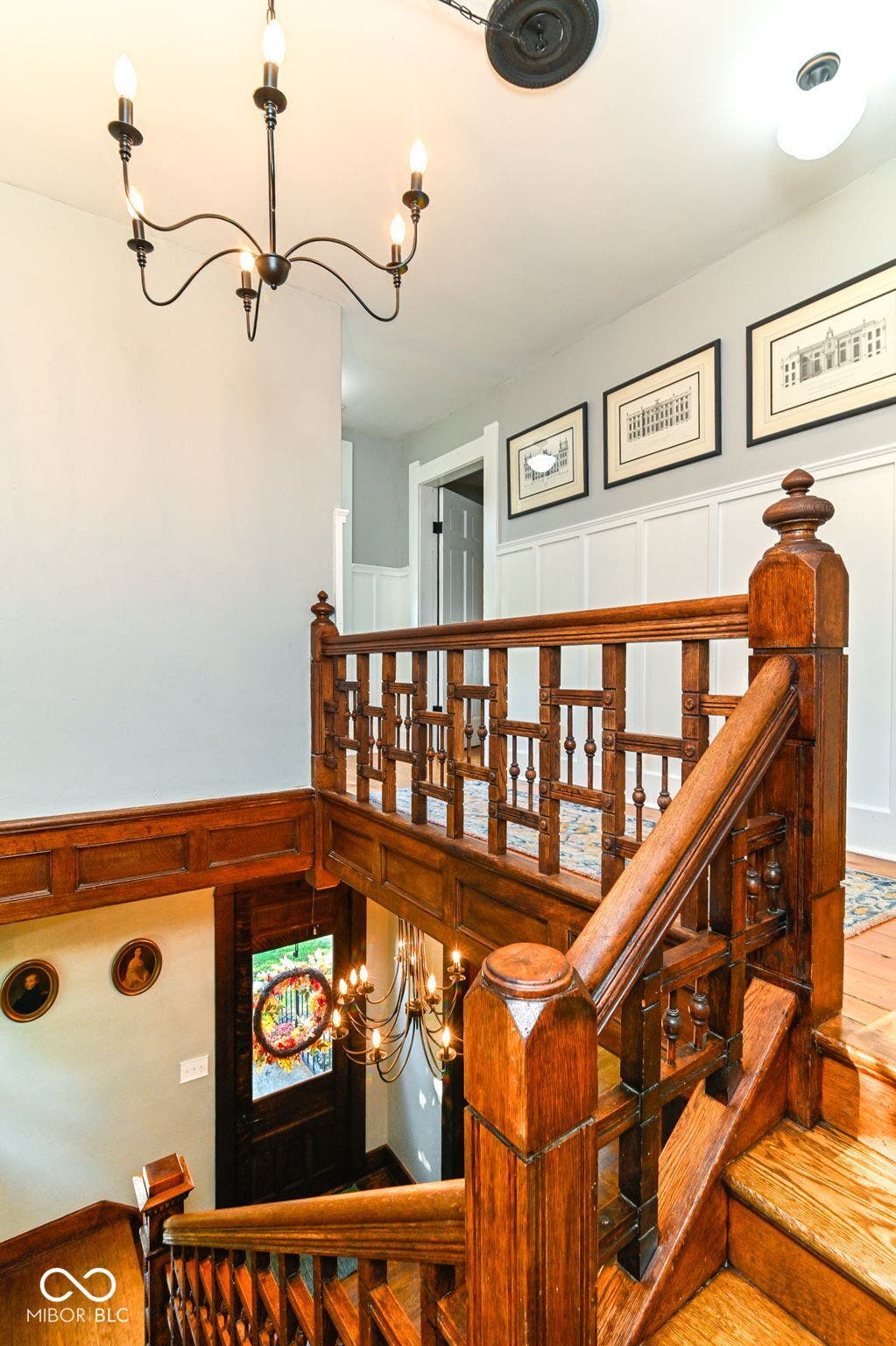 A look down the extraordinary original staircase showcases detailed wood railings and the home's craftsmanship from every level.