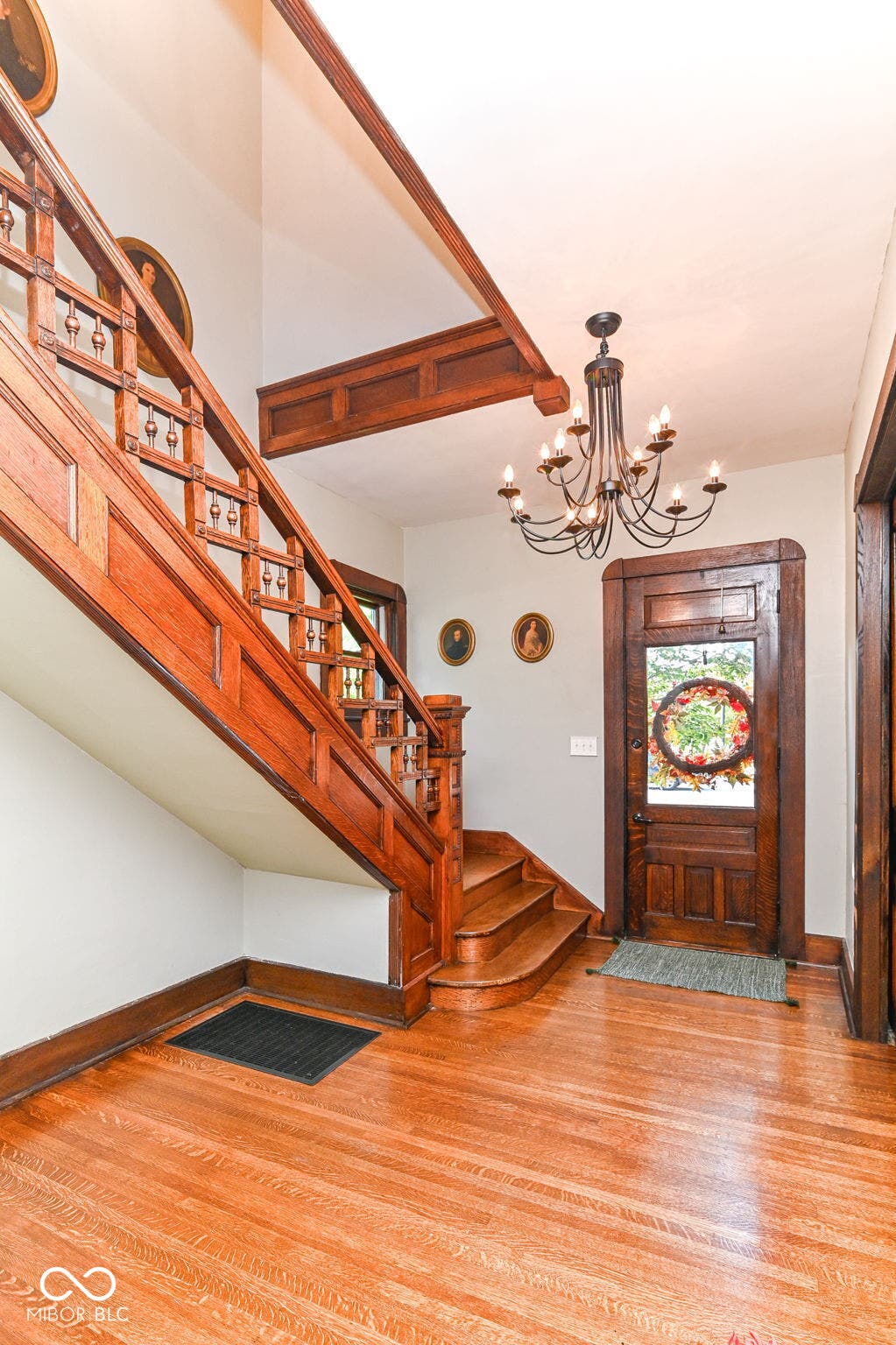 Another view of the statement staircase and original front entry - craftsmanship rarely found in modern construction.