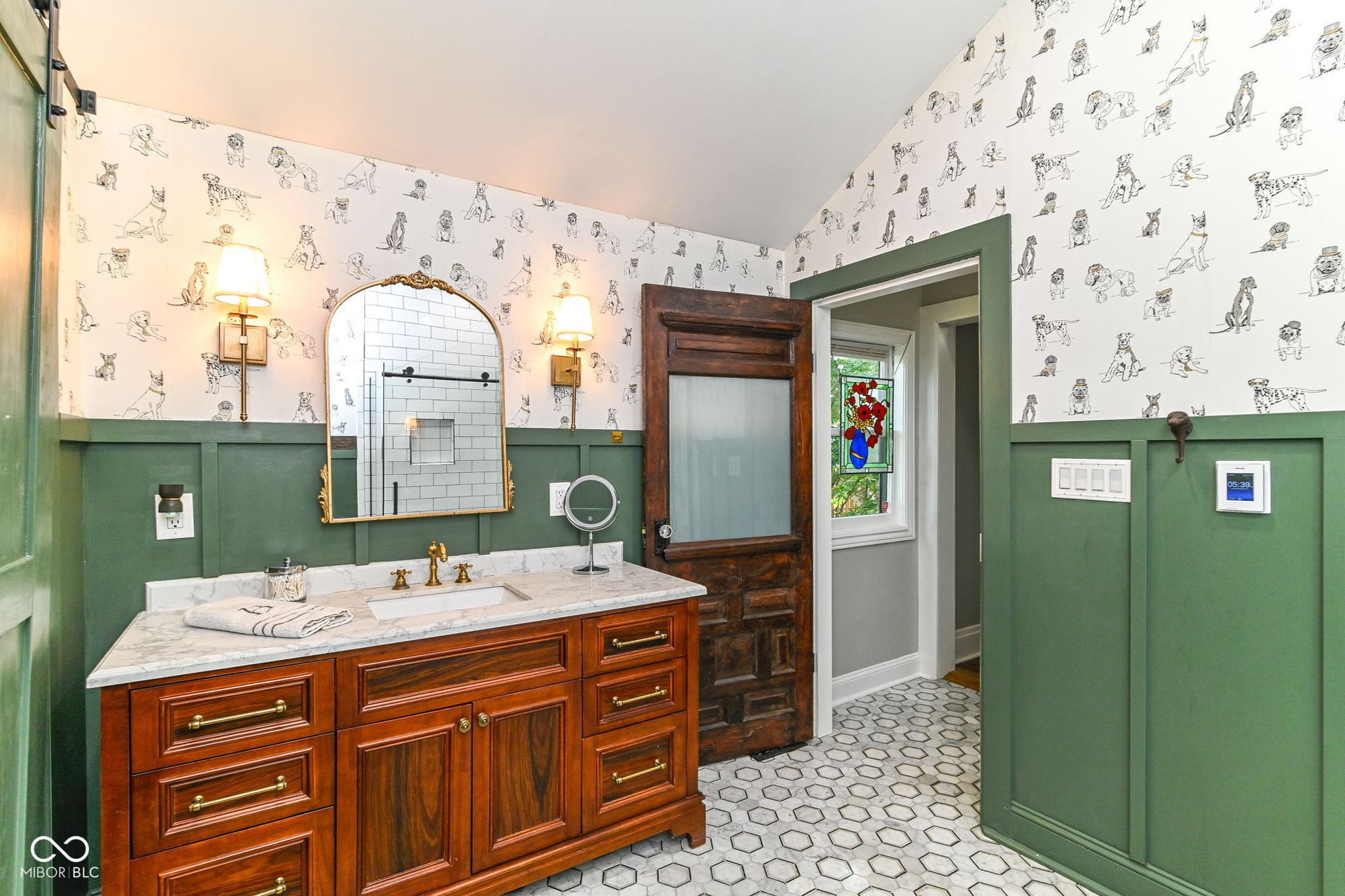 Main-level bath features heated marble flooring, tiled shower, marble-topped vanity, brass-toned fixtures and charming period-inspired details.