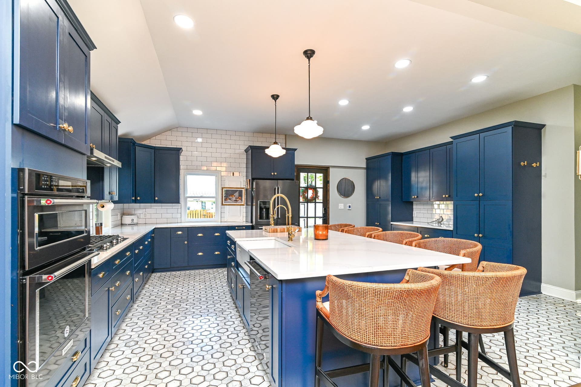 Showstopper renovated kitchen with heated marble floors, deep-blue all-wood cabinetry, quartz counters, KitchenAid appliances and island seating for 6.