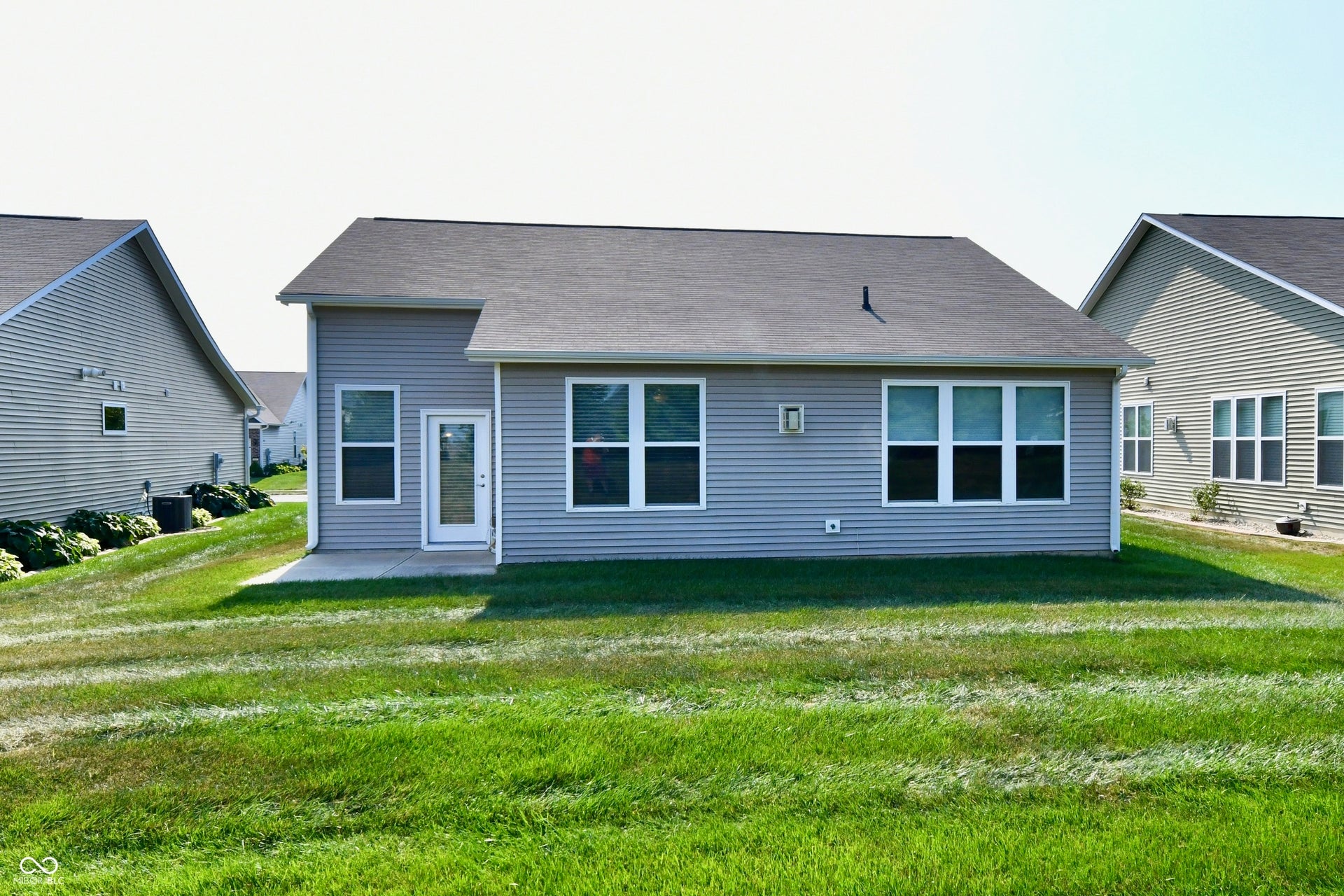 Rear exterior with light gray siding and a dark shingle roof