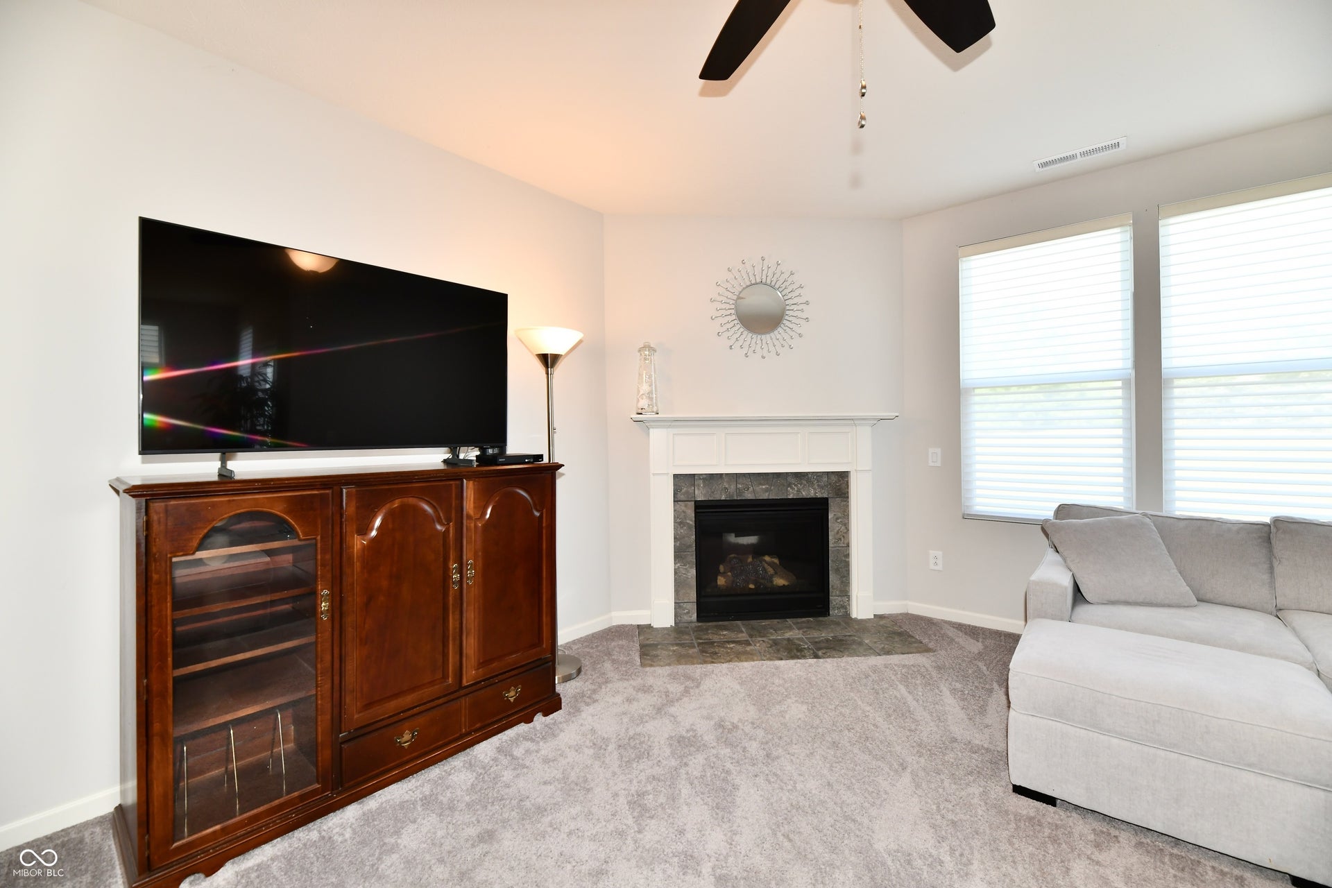 Corner fireplace with a white mantel and stone surround