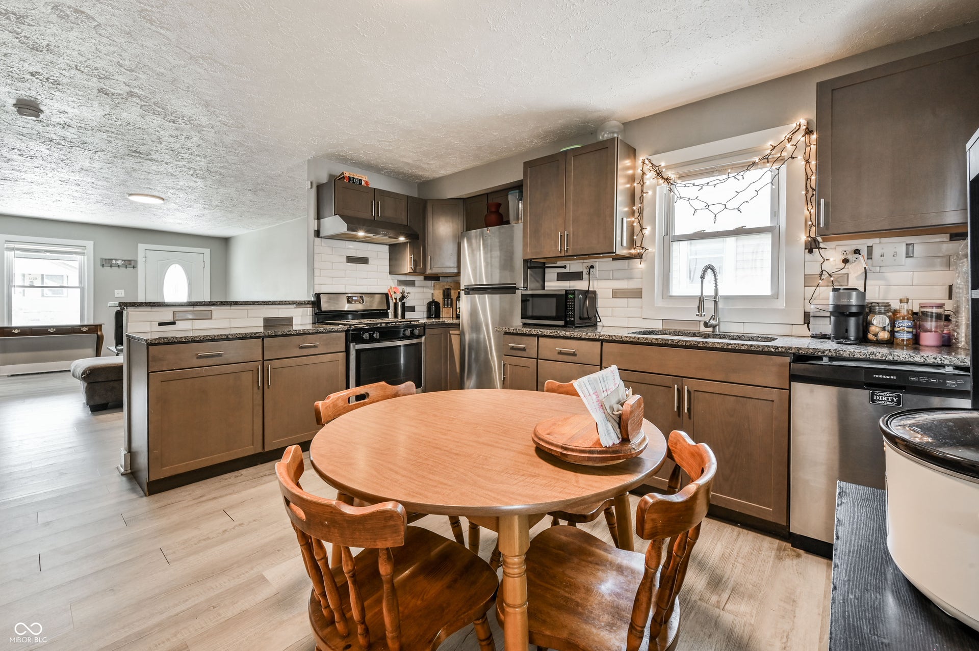 1530 Dawson Street, Indianapolis, IN 46203 Kitchen featuring wood-finish cabinetry, stainless steel appliances, granite-style countertops, subway tile backsplash