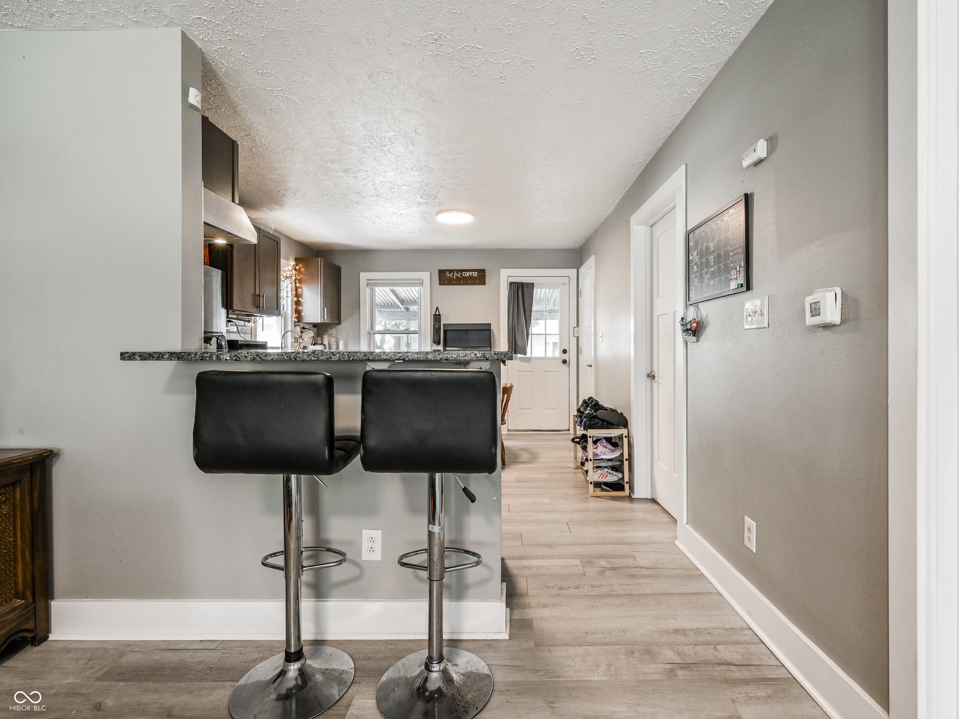 1530 Dawson Street, Indianapolis, IN 46203 Kitchen bar with a granite-look countertop, wood-finish flooring, and light gray walls