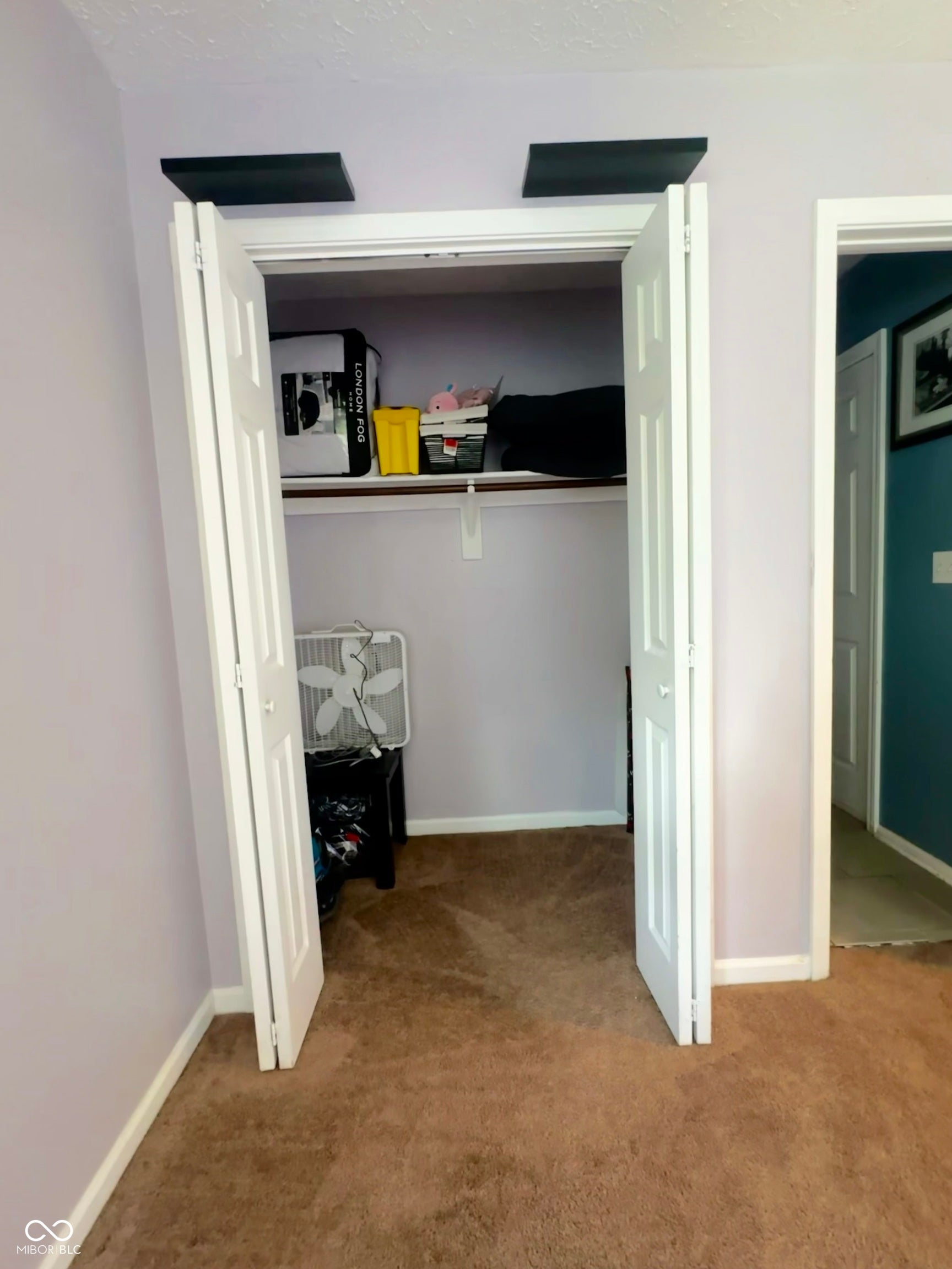 Bi-fold closet doors with interior shelving and clothing rod