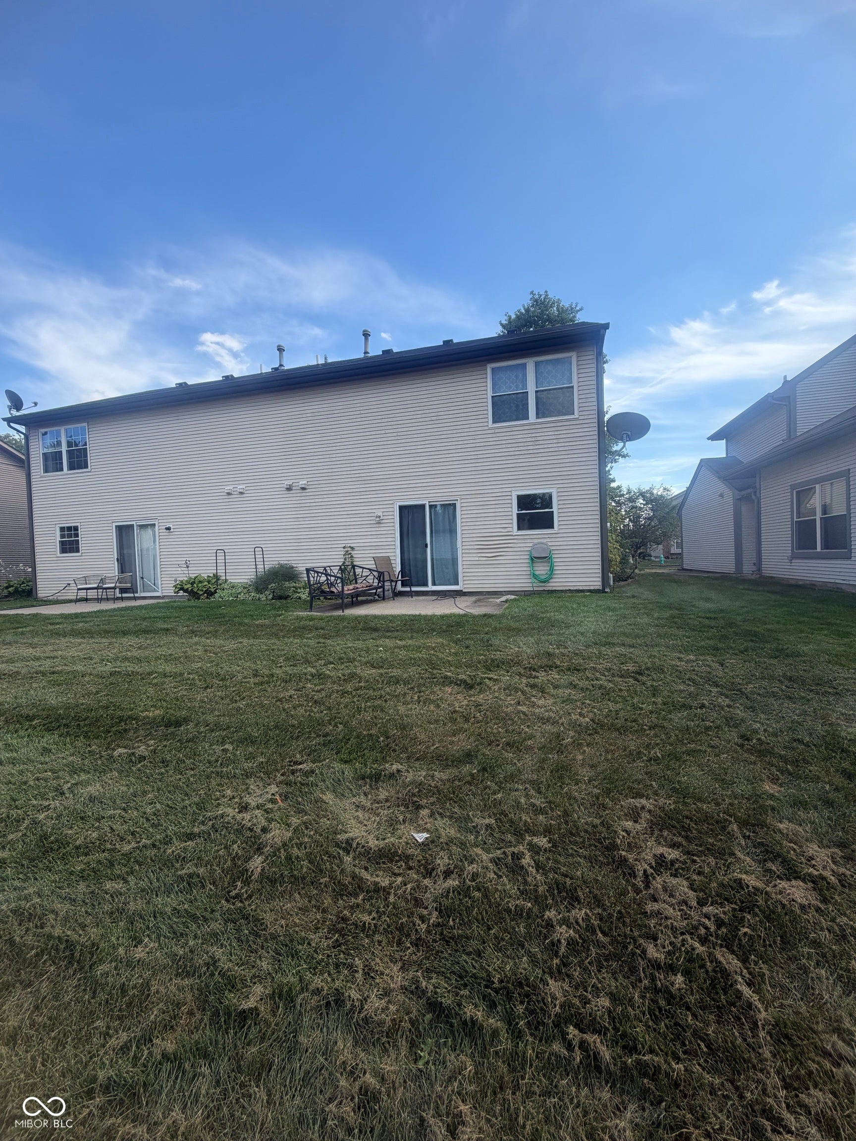 rear lawn with a patio area and dual sliding glass doors