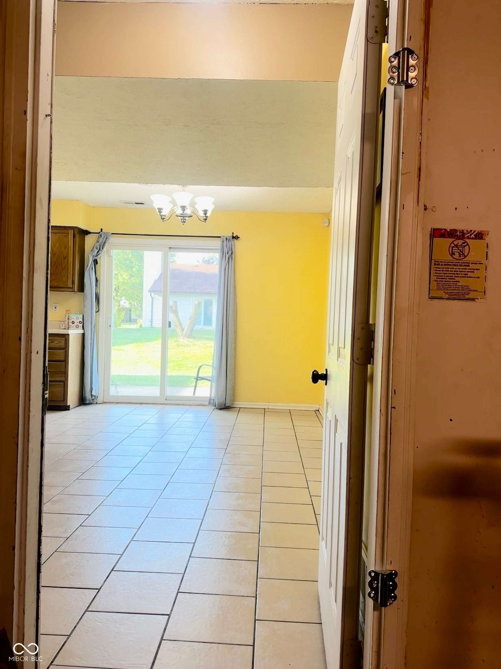 Tile flooring throughout, sliding glass door, and a ceiling-mounted light fixture