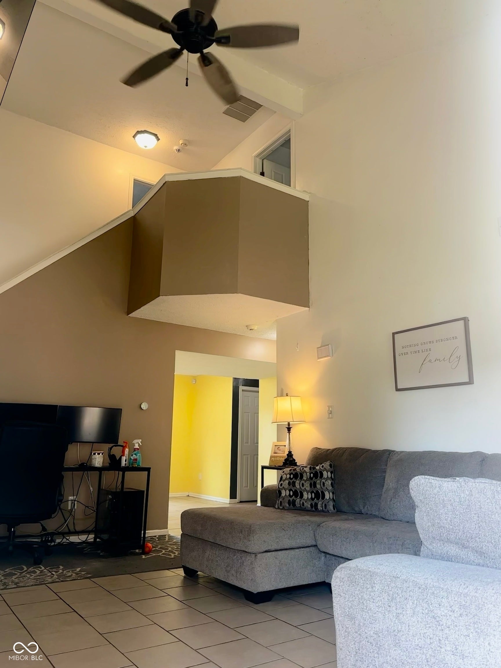 Two-story ceiling, ceiling fan, tile flooring, interior balcony, and recessed lighting