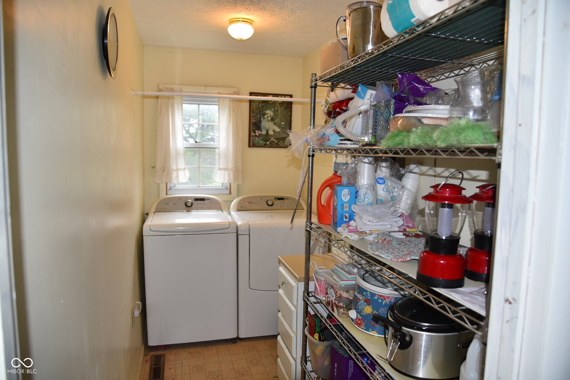 Laundry area with window, overhead lighting, and vinyl flooring