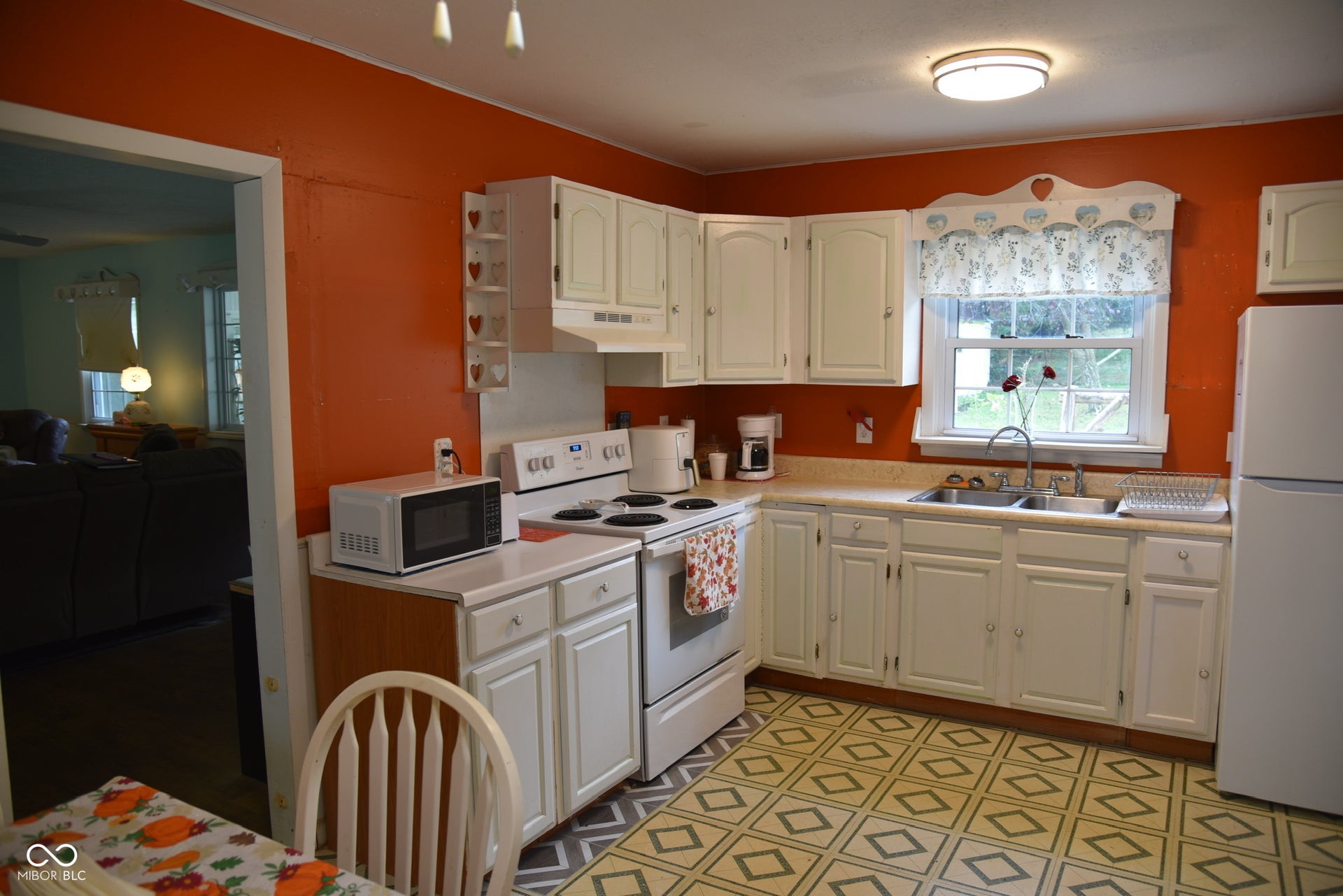 White cabinetry, dual-basin stainless steel sink, and durable laminate countertops