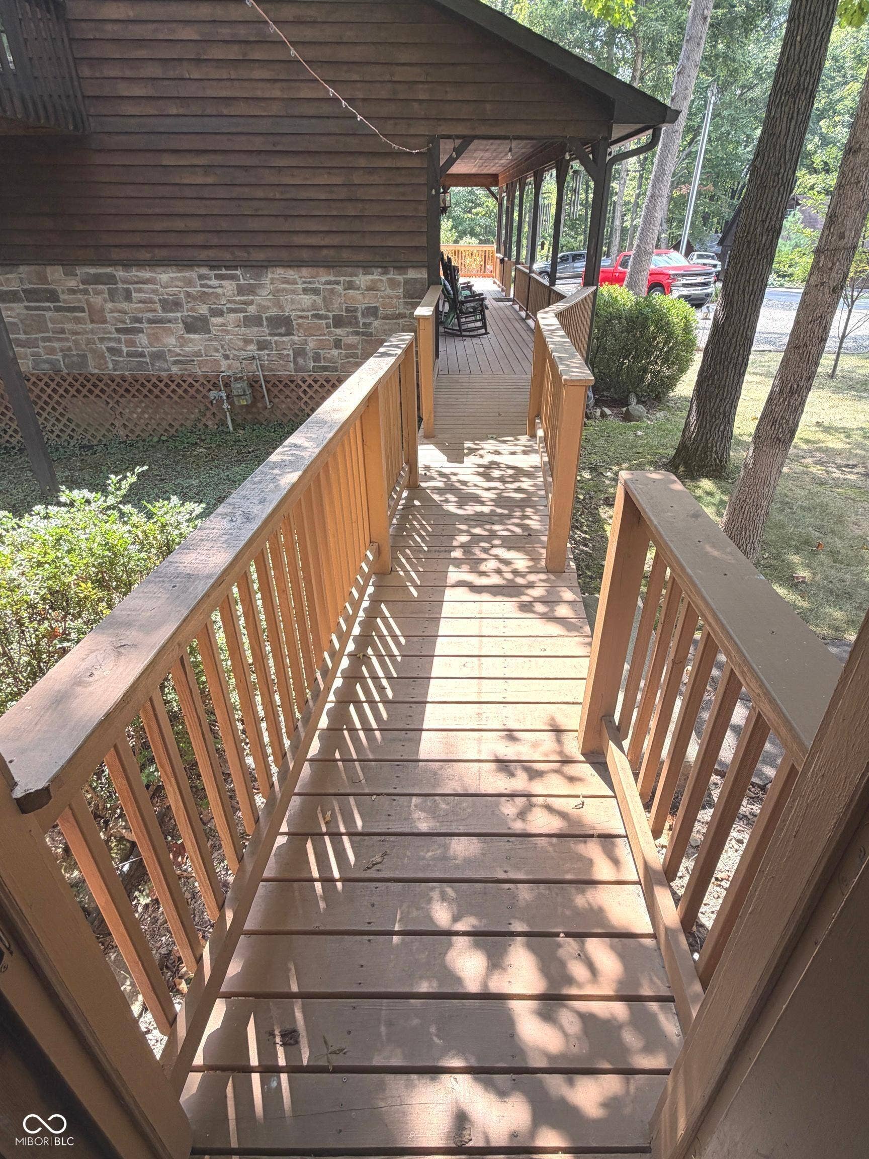 Wood-finish ramp with railings providing access to a covered porch
