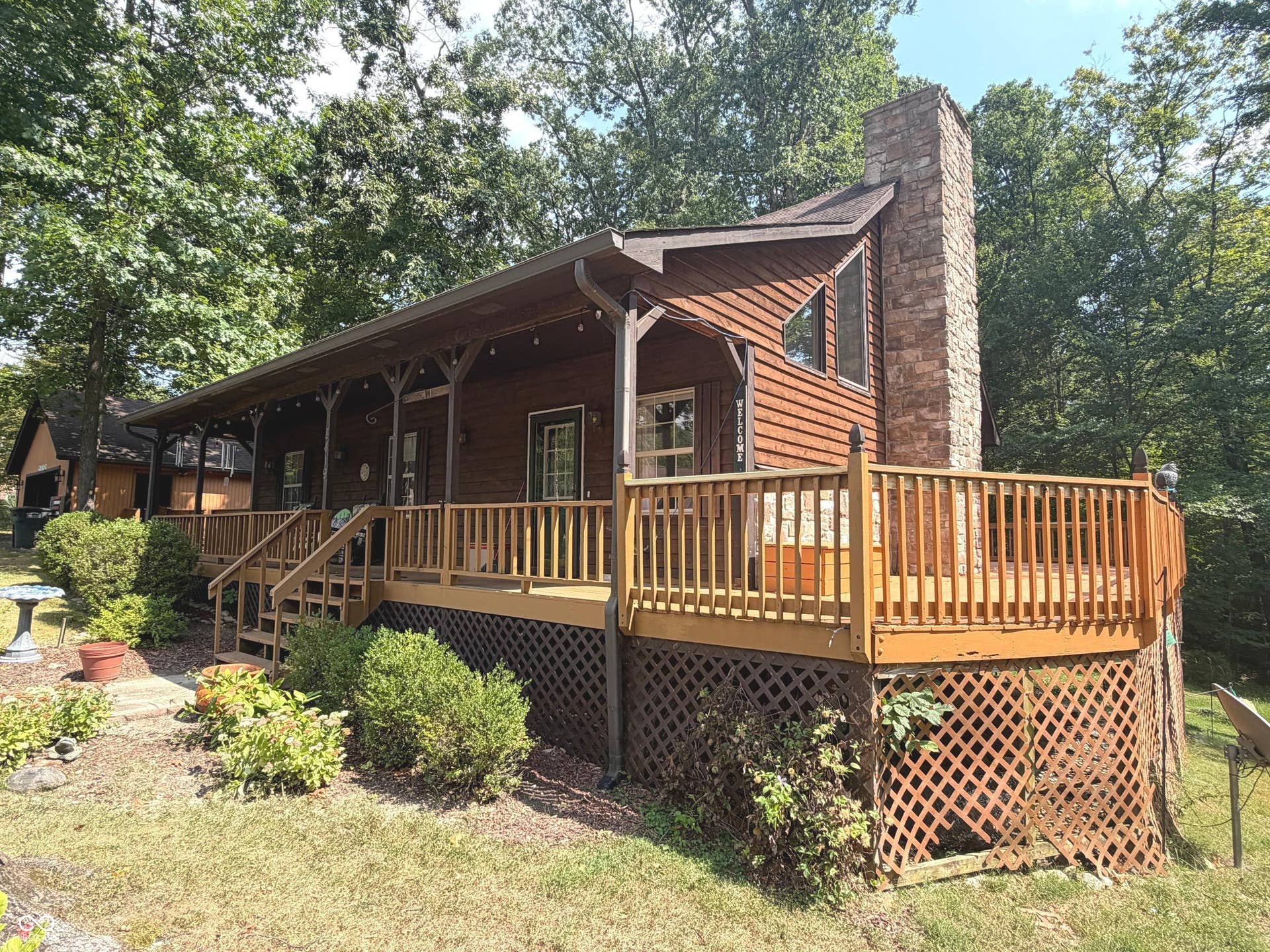 Expansive wood deck with lattice skirting and a prominent stone chimney