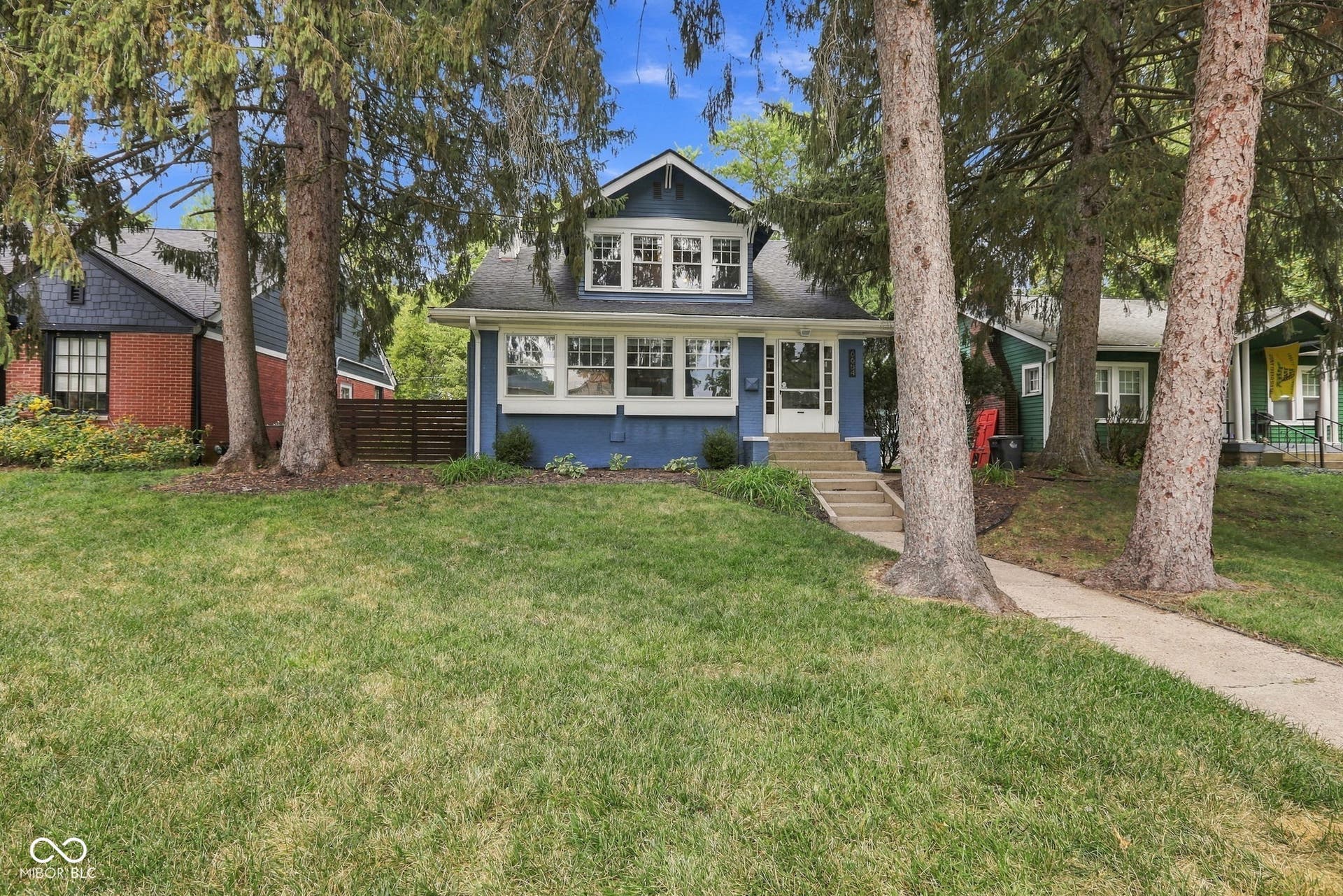 Blue exterior with white trim, a gabled roof, and multiple windows