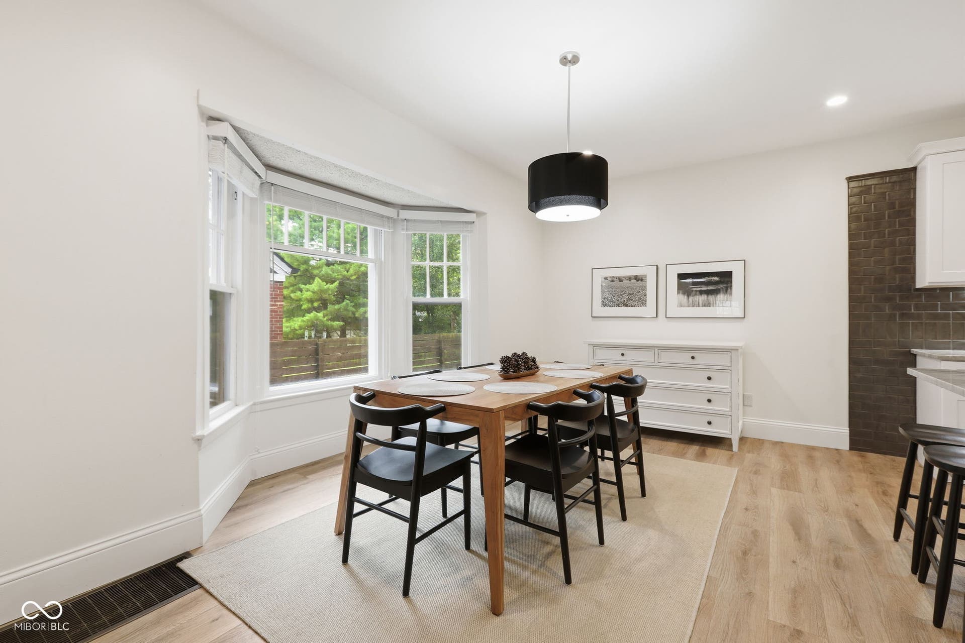 Bay window with multiple panes, wood-finish flooring, recessed lighting, and a drum pendant light fixture