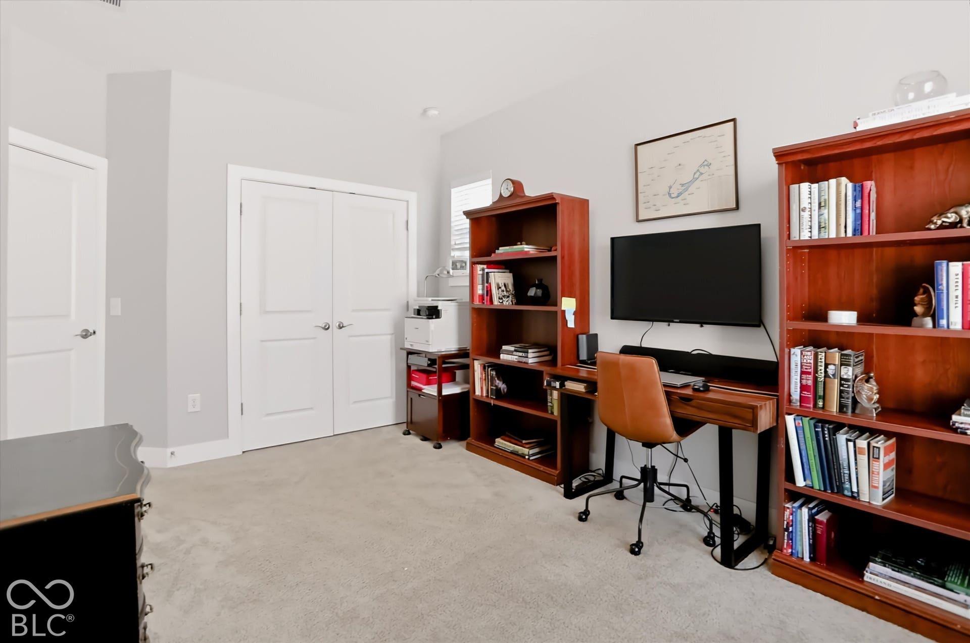 Bedroom 3 currently used as an office. Neutral wall paint throughout Neutral wall paint, light-toned carpeting, and a built-in double-door closet