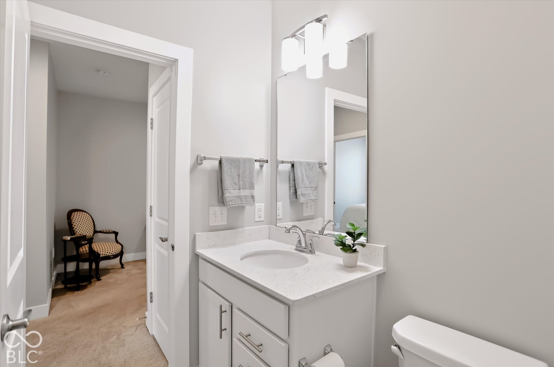 White vanity with integrated sink, stone-look countertop, and chrome faucet