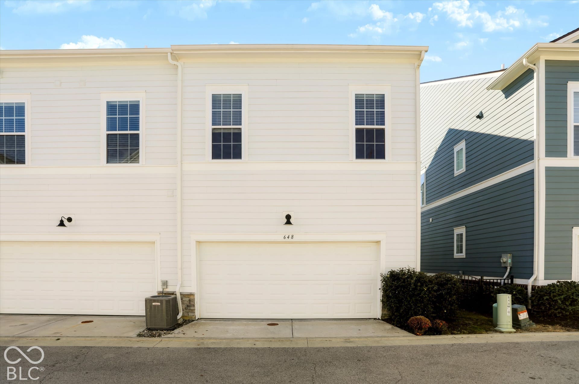 White siding exterior with multiple windows and attached garage